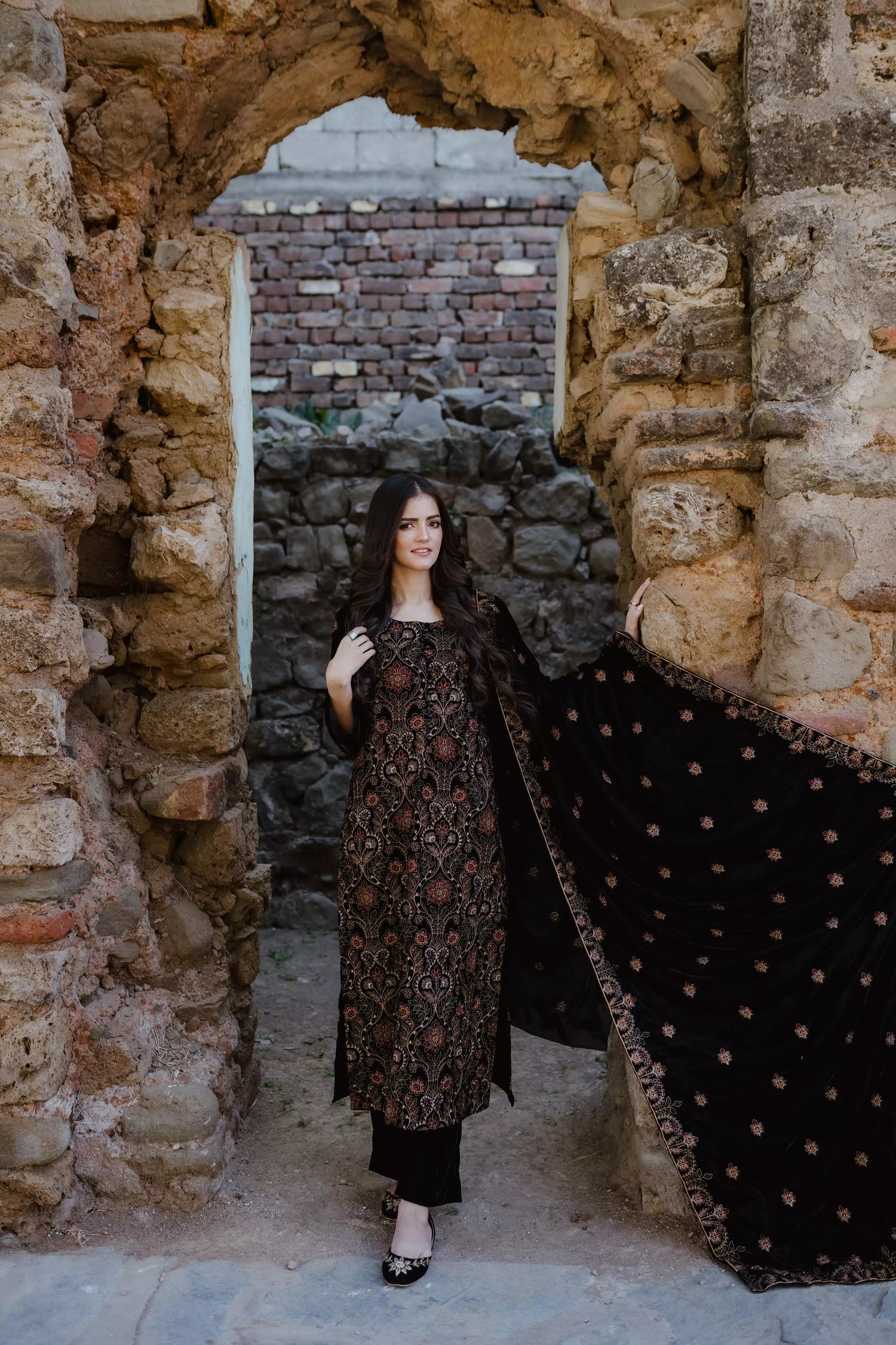 Black velvet suit features intricate multi-thread embroidery on the shirt, paired with plain velvet pants and a matching velvet shawl with embroidered borders for a refined, luxurious look.