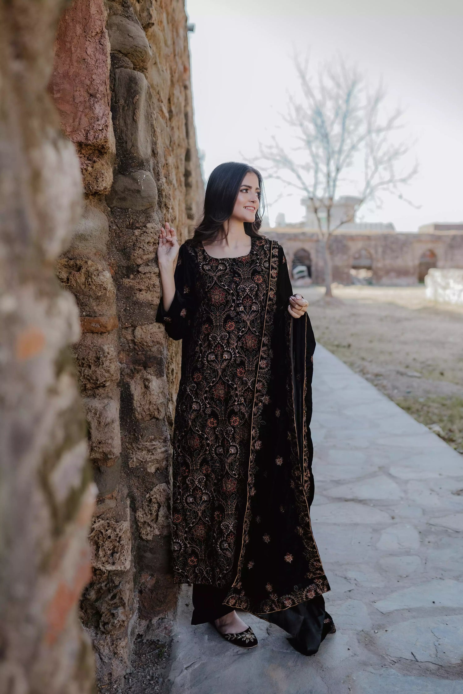 Black velvet suit features intricate multi-thread embroidery on the shirt, paired with plain velvet pants and a matching velvet shawl with embroidered borders for a refined, luxurious look.