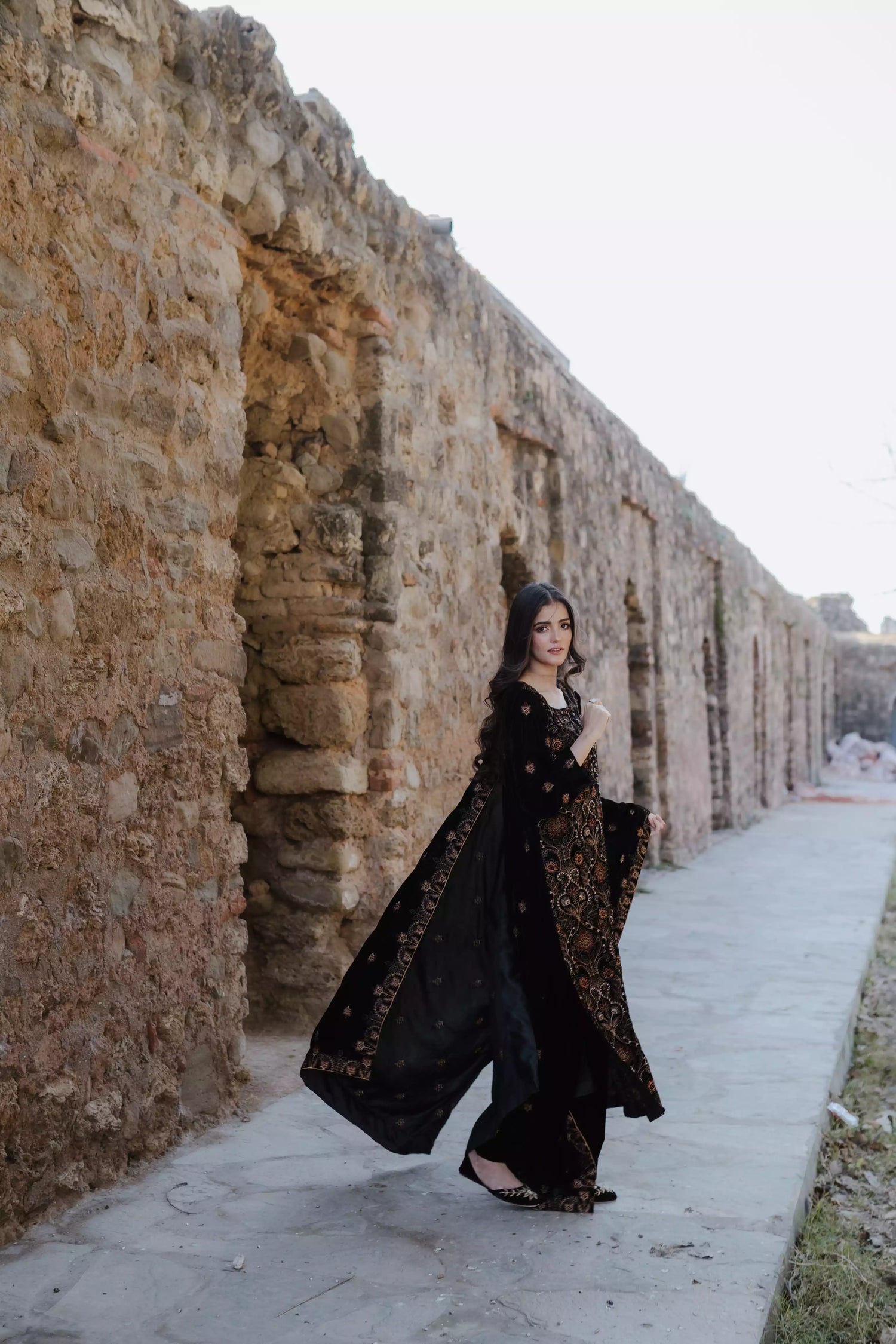 Black velvet suit features intricate multi-thread embroidery on the shirt, paired with plain velvet pants and a matching velvet shawl with embroidered borders for a refined, luxurious look.