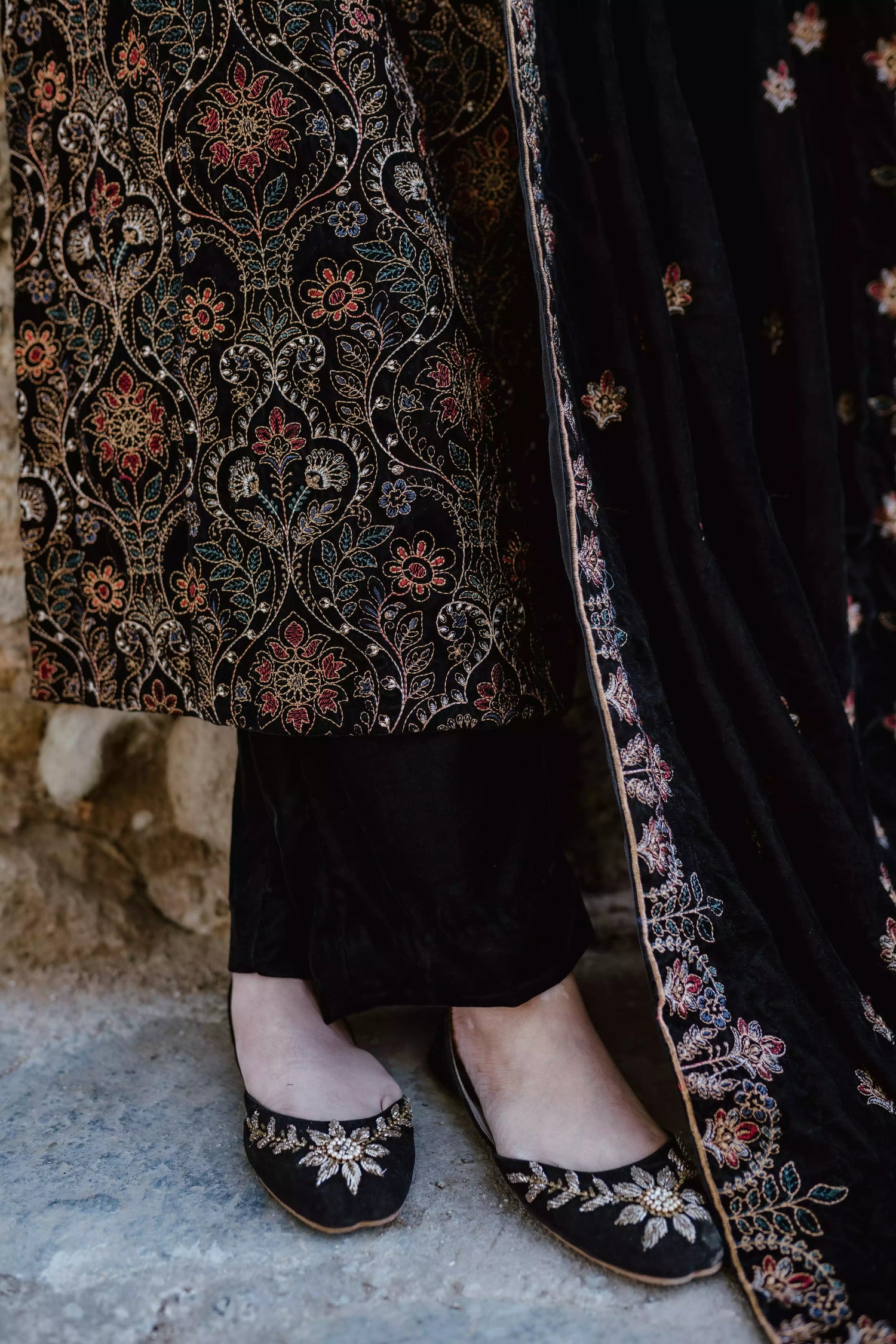 Black velvet suit features intricate multi-thread embroidery on the shirt, paired with plain velvet pants and a matching velvet shawl with embroidered borders for a refined, luxurious look.
