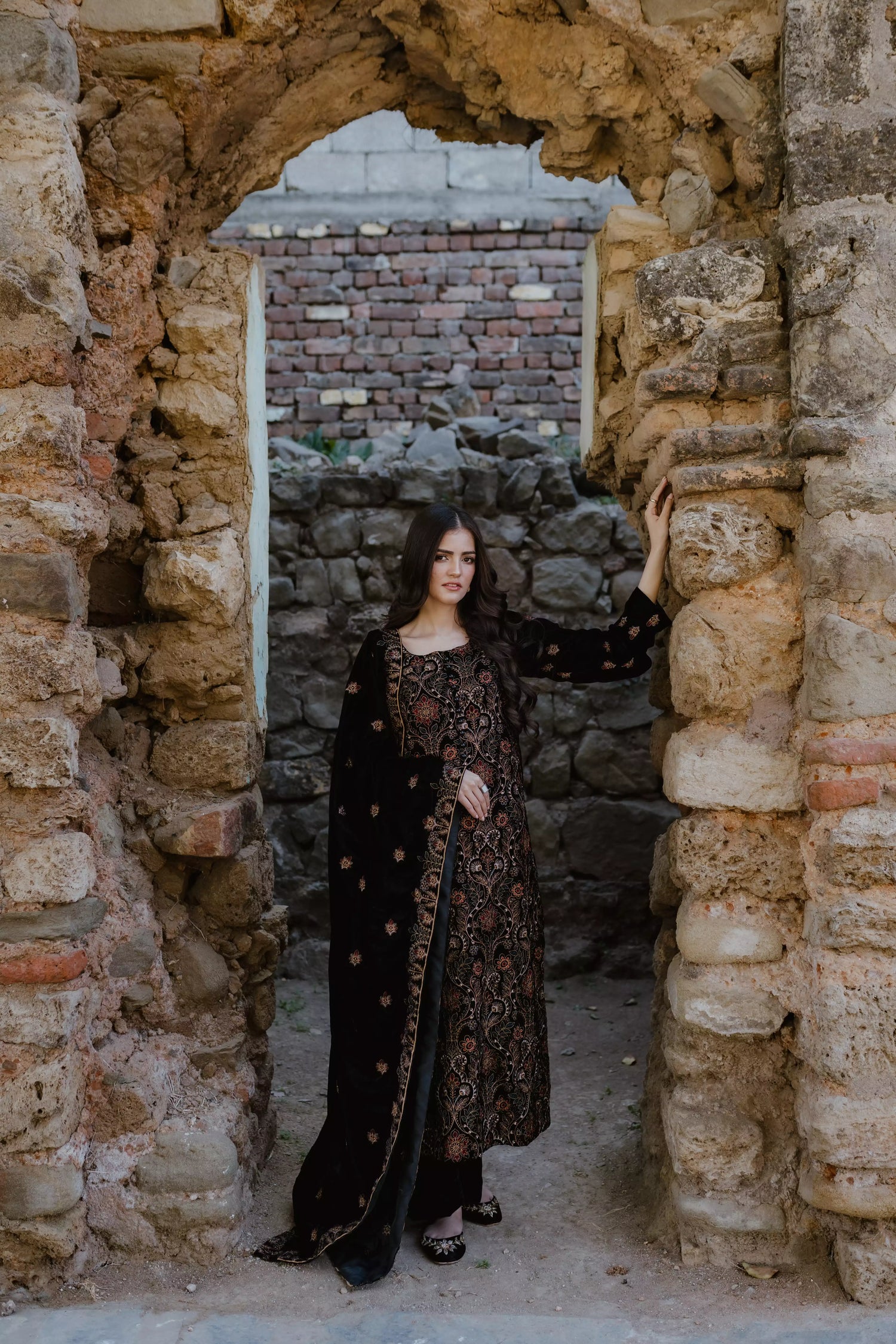 Black velvet suit features intricate multi-thread embroidery on the shirt, paired with plain velvet pants and a matching velvet shawl with embroidered borders for a refined, luxurious look.