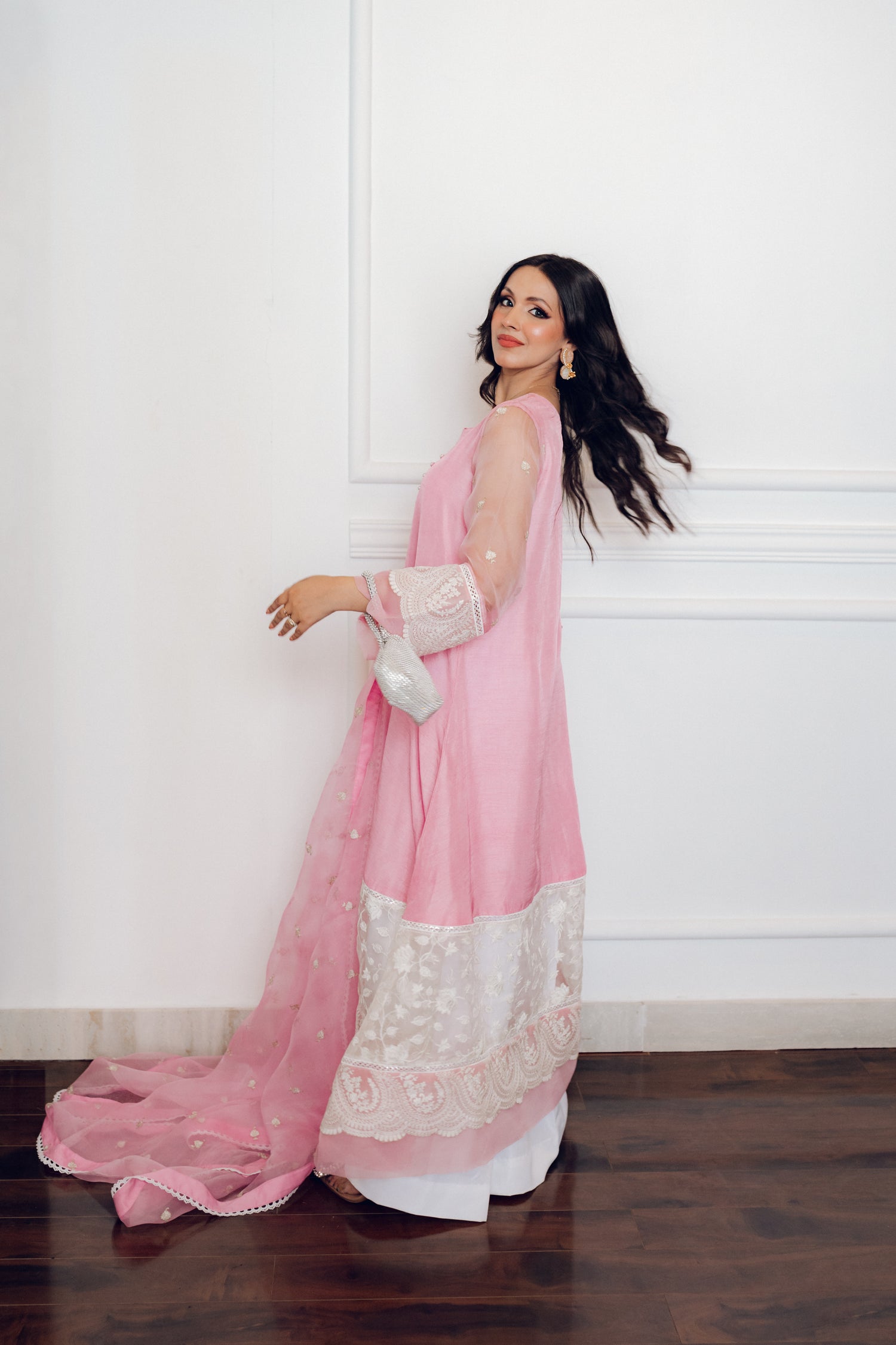 A delicate pink dress adorned with lace and pearl buttons, exuding romance and timeless sophistication.