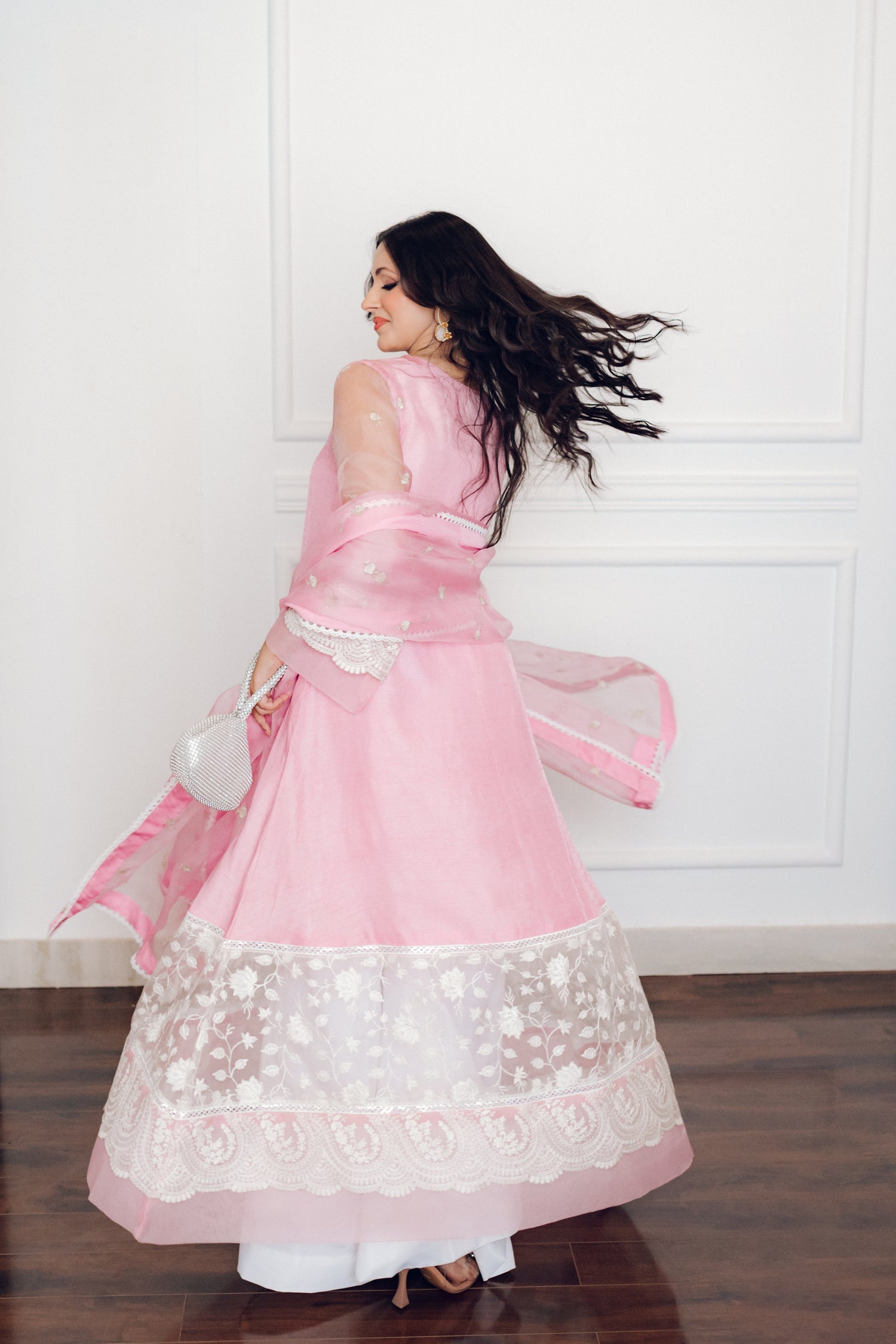 A delicate pink dress adorned with lace and pearl buttons, exuding romance and timeless sophistication.