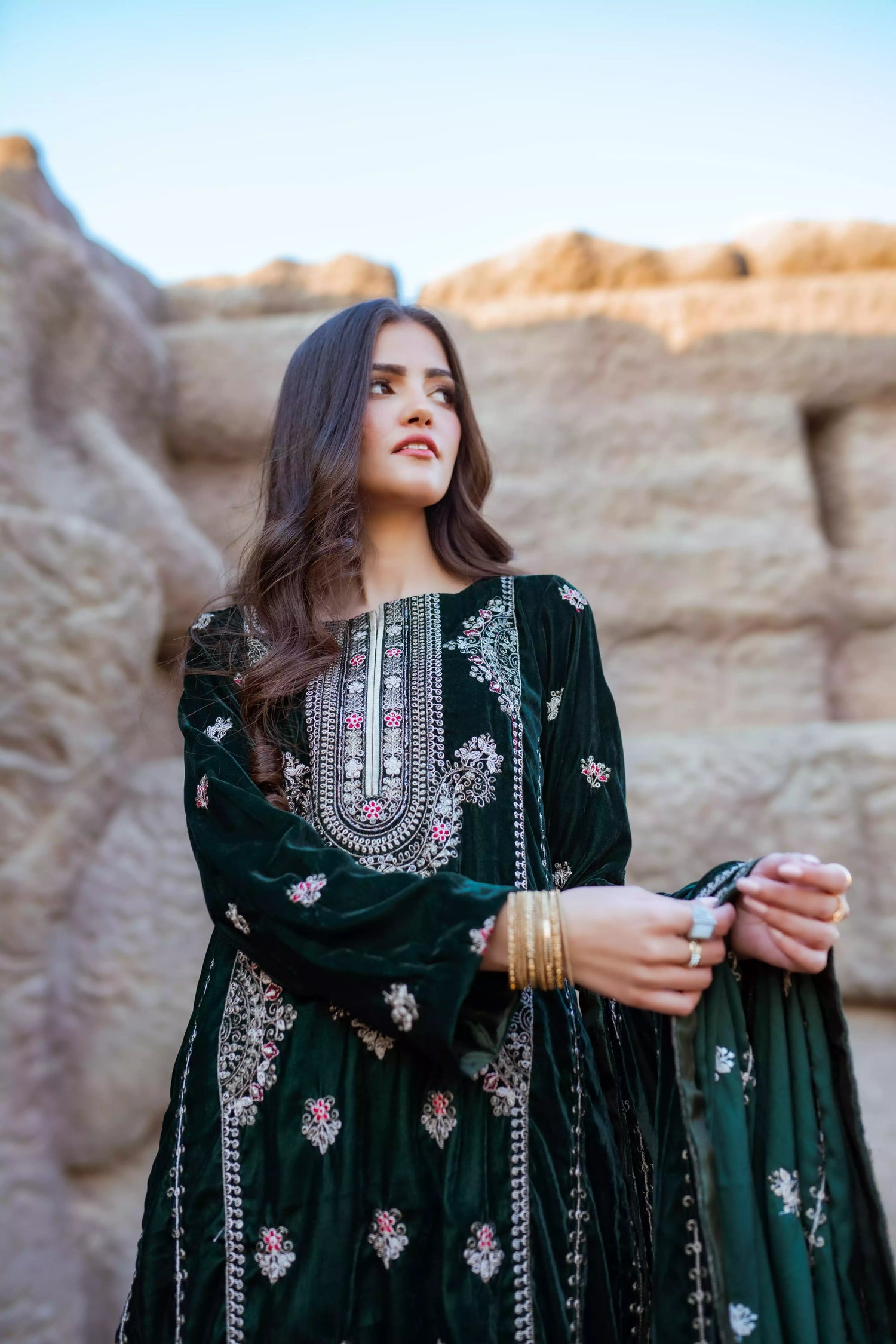 Emerald green velvet suit with cream thread embroidery, paired with an embroidered shawl and plain velvet pants for an elegant, luxurious look.