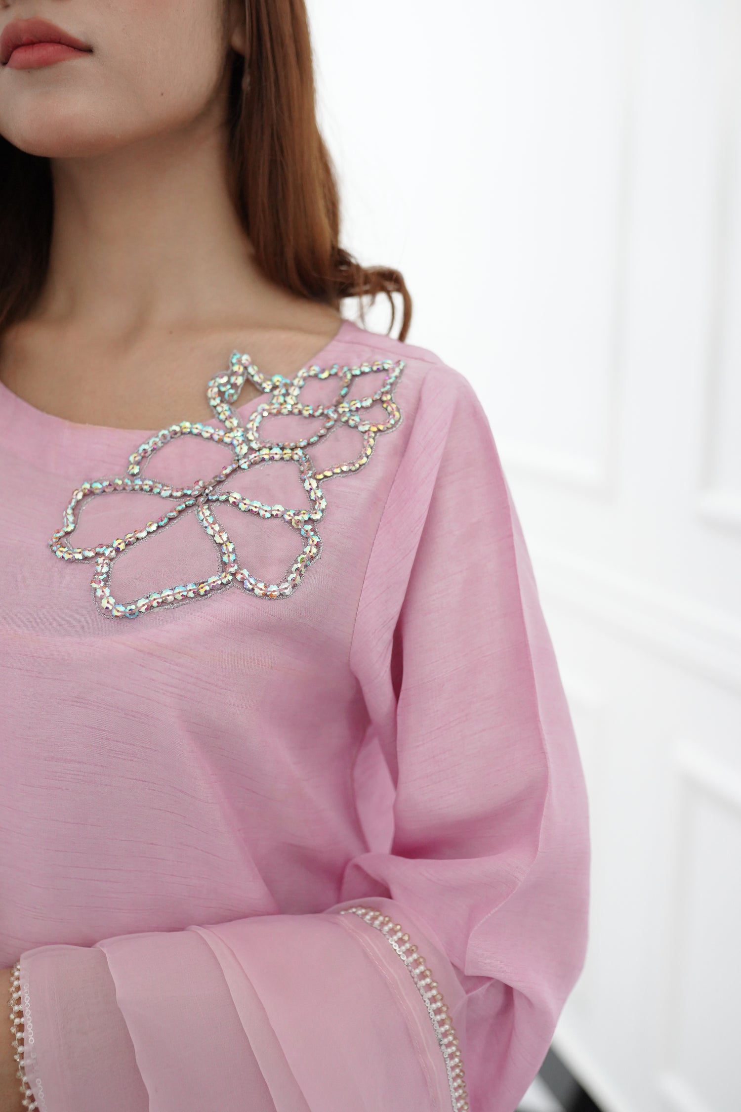 A sophisticated light pink dress with floral rhinestones showcasing style and elegance.