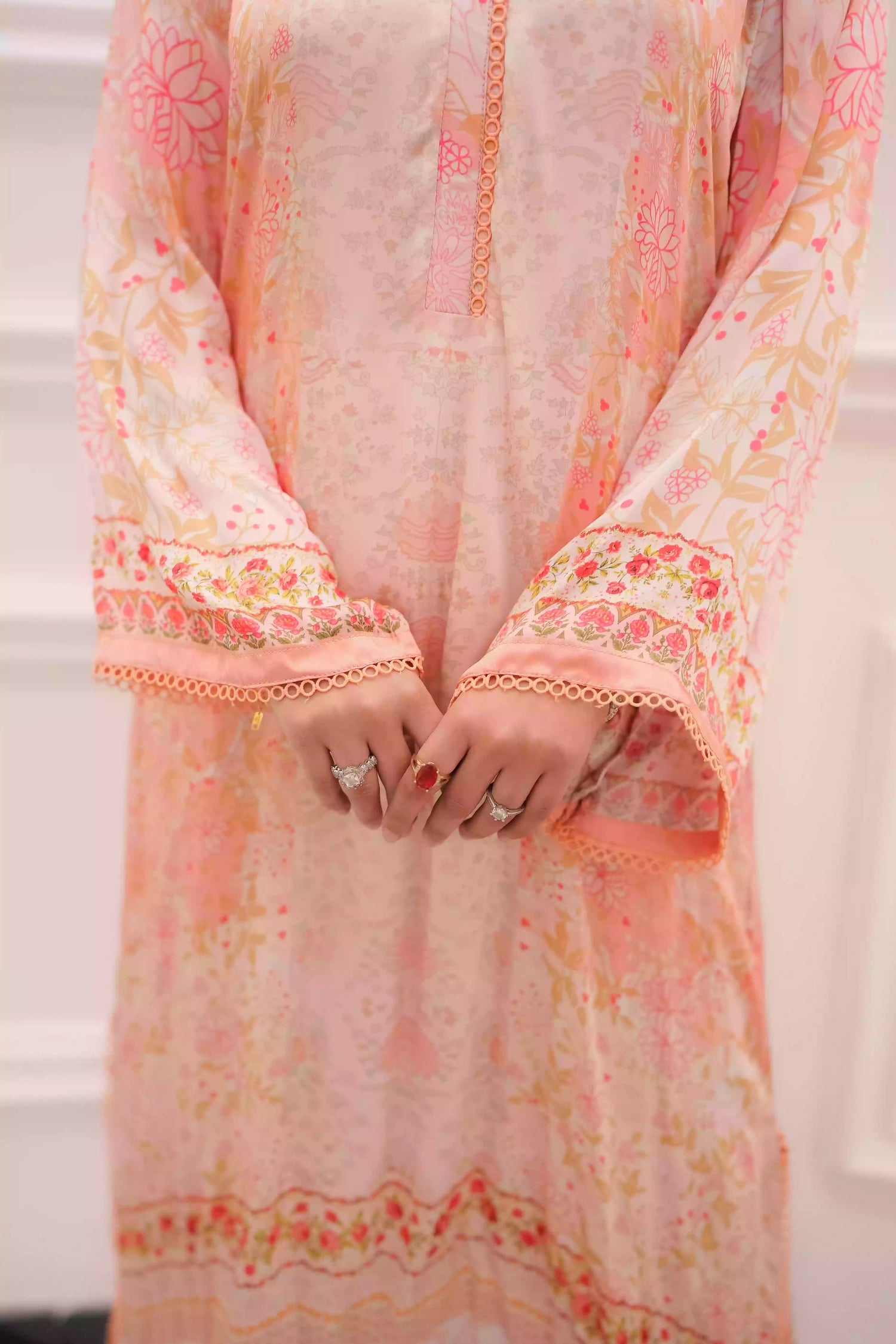 Discover two-tone pastel peach silk kurta featuring a delicate floral digital print and a flowing draped silhouette. The design is detailed with subtle lace accents along the neckline and hem, offering a soft, feminine look suitable for  festive gatherings, and semi-formal occasions.