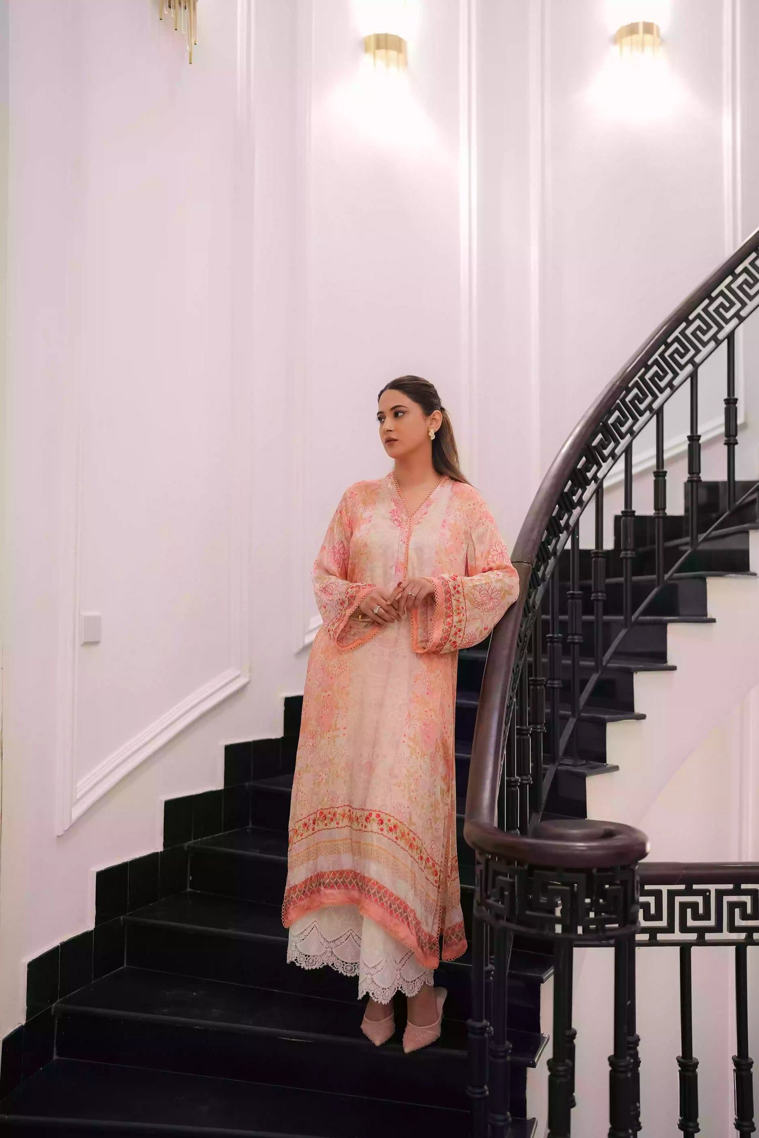 Discover two-tone pastel peach silk kurta featuring a delicate floral digital print and a flowing draped silhouette. The design is detailed with subtle lace accents along the neckline and hem, offering a soft, feminine look suitable for  festive gatherings, and semi-formal occasions.