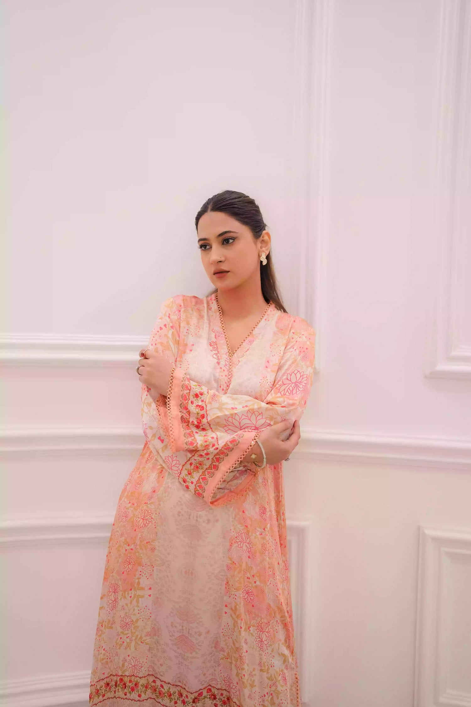 Discover two-tone pastel peach silk kurta featuring a delicate floral digital print and a flowing draped silhouette. The design is detailed with subtle lace accents along the neckline and hem, offering a soft, feminine look suitable for  festive gatherings, and semi-formal occasions.