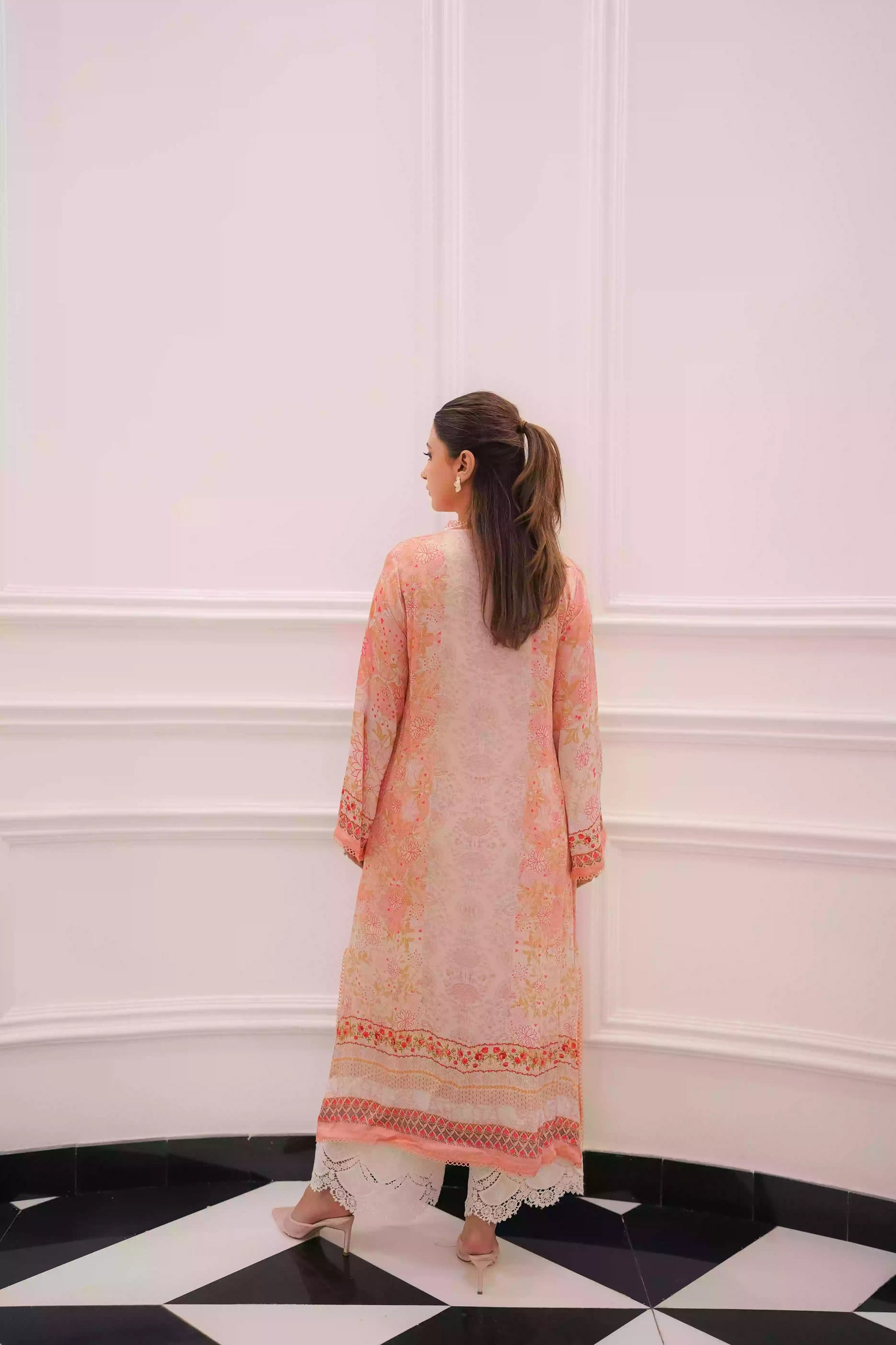 Discover two-tone pastel peach silk kurta featuring a delicate floral digital print and a flowing draped silhouette. The design is detailed with subtle lace accents along the neckline and hem, offering a soft, feminine look suitable for  festive gatherings, and semi-formal occasions.