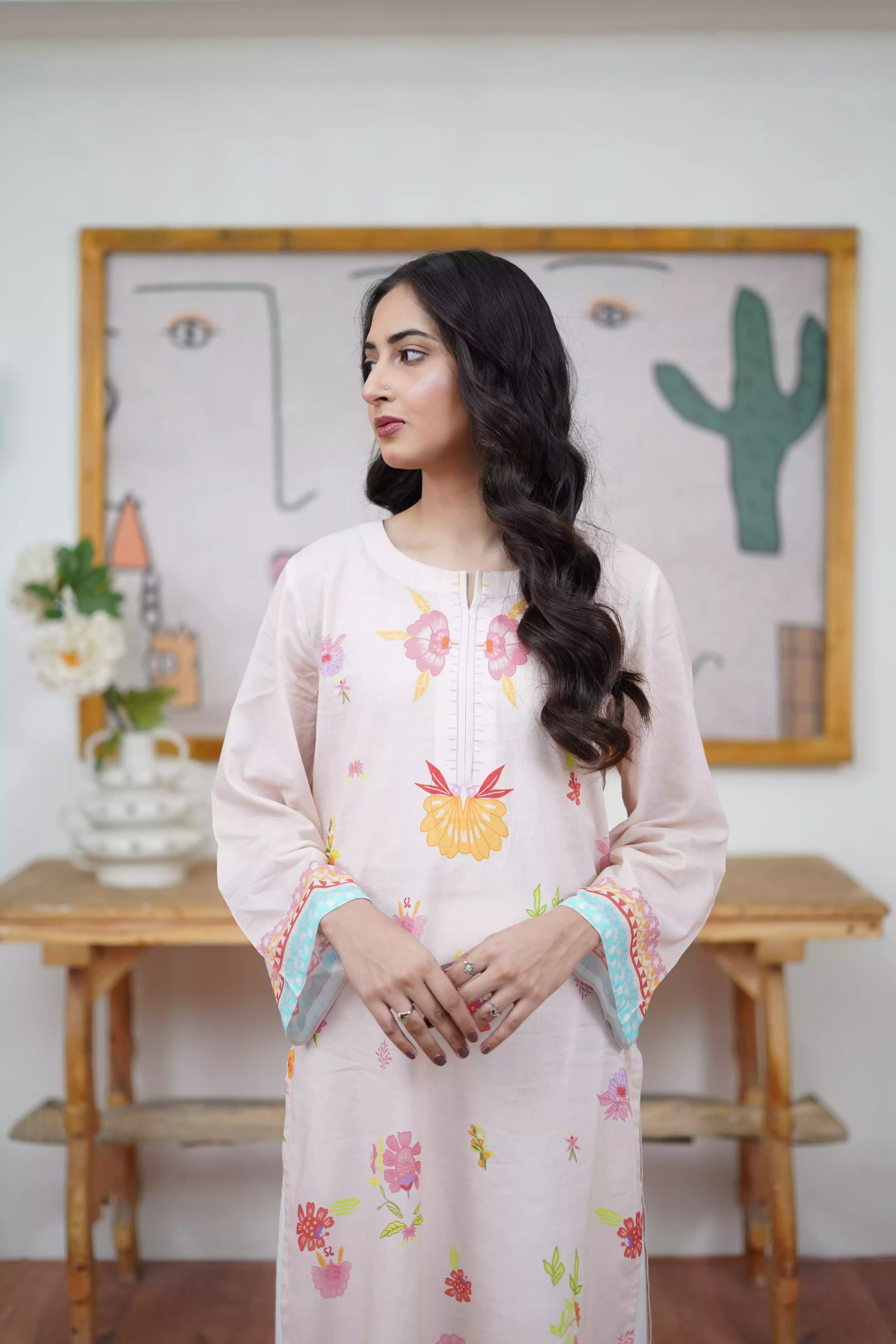A cream-toned ensemble adorned with pastel florals and delicate neckline detailing.