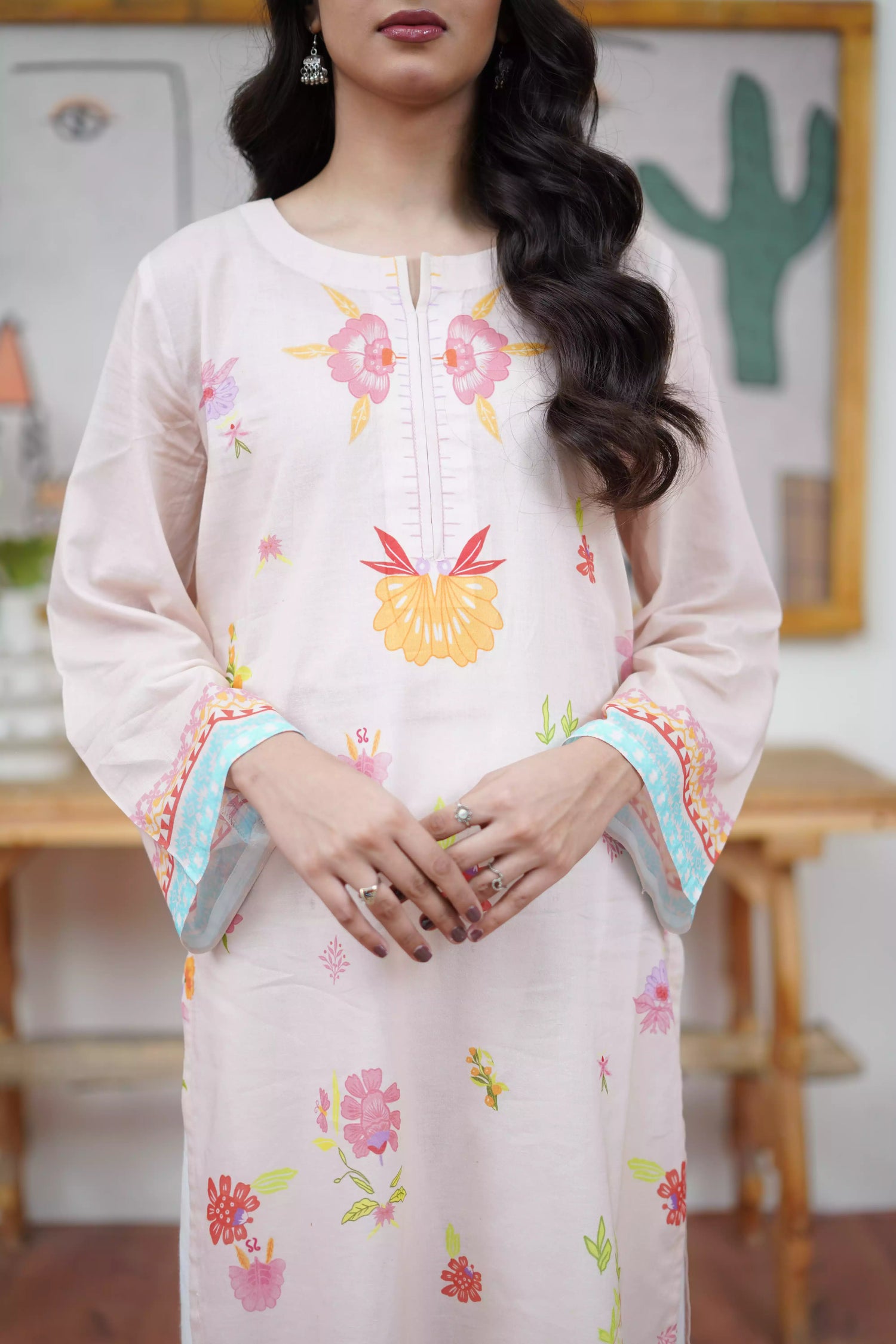 A cream-toned ensemble adorned with pastel florals and delicate neckline detailing.