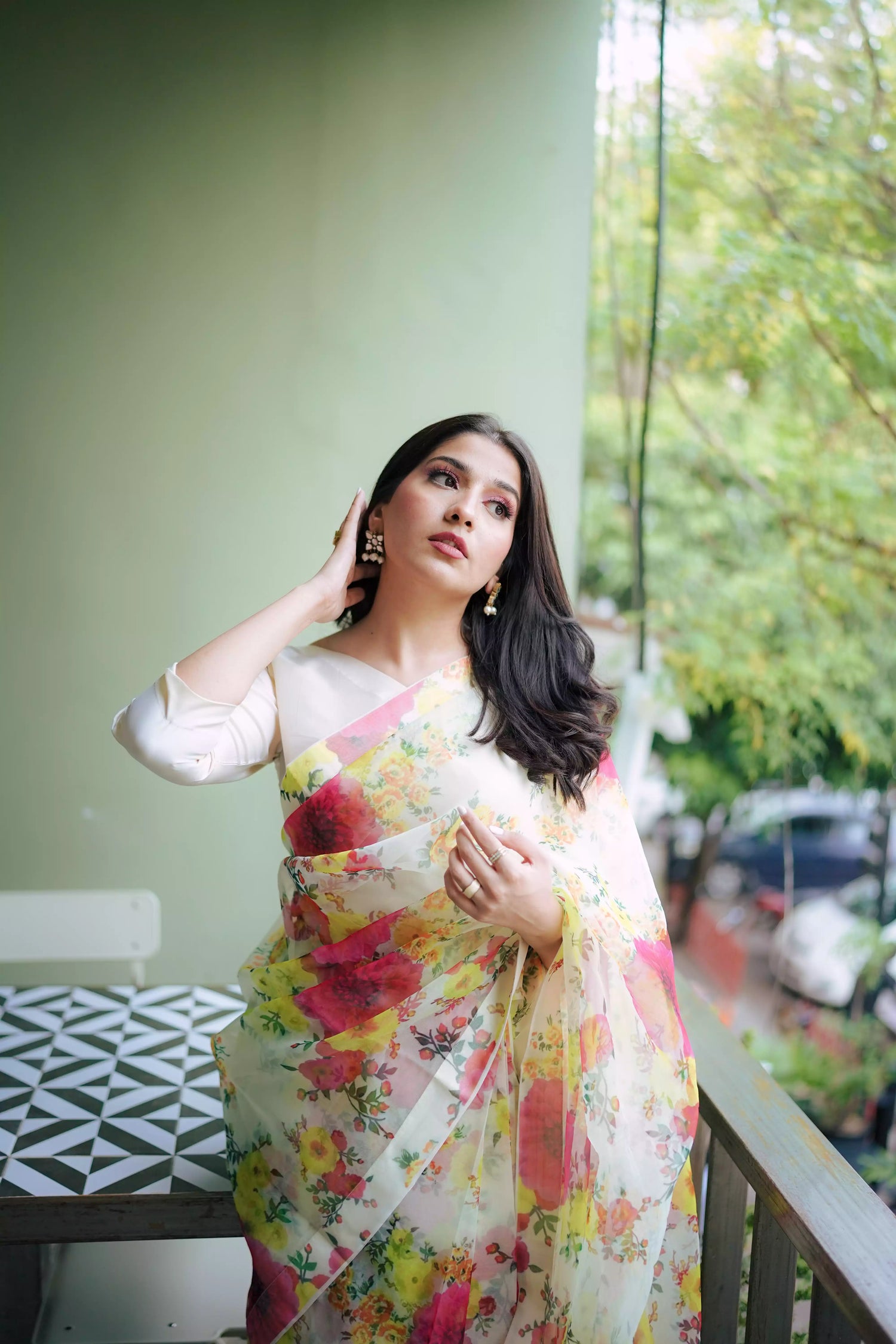 Cream floral printed organza saree with soft pastel patterns, paired with a matching Katan raw silk blouse and cotton petticoat; elegant drape ideal for festive and semi-formal occasions.