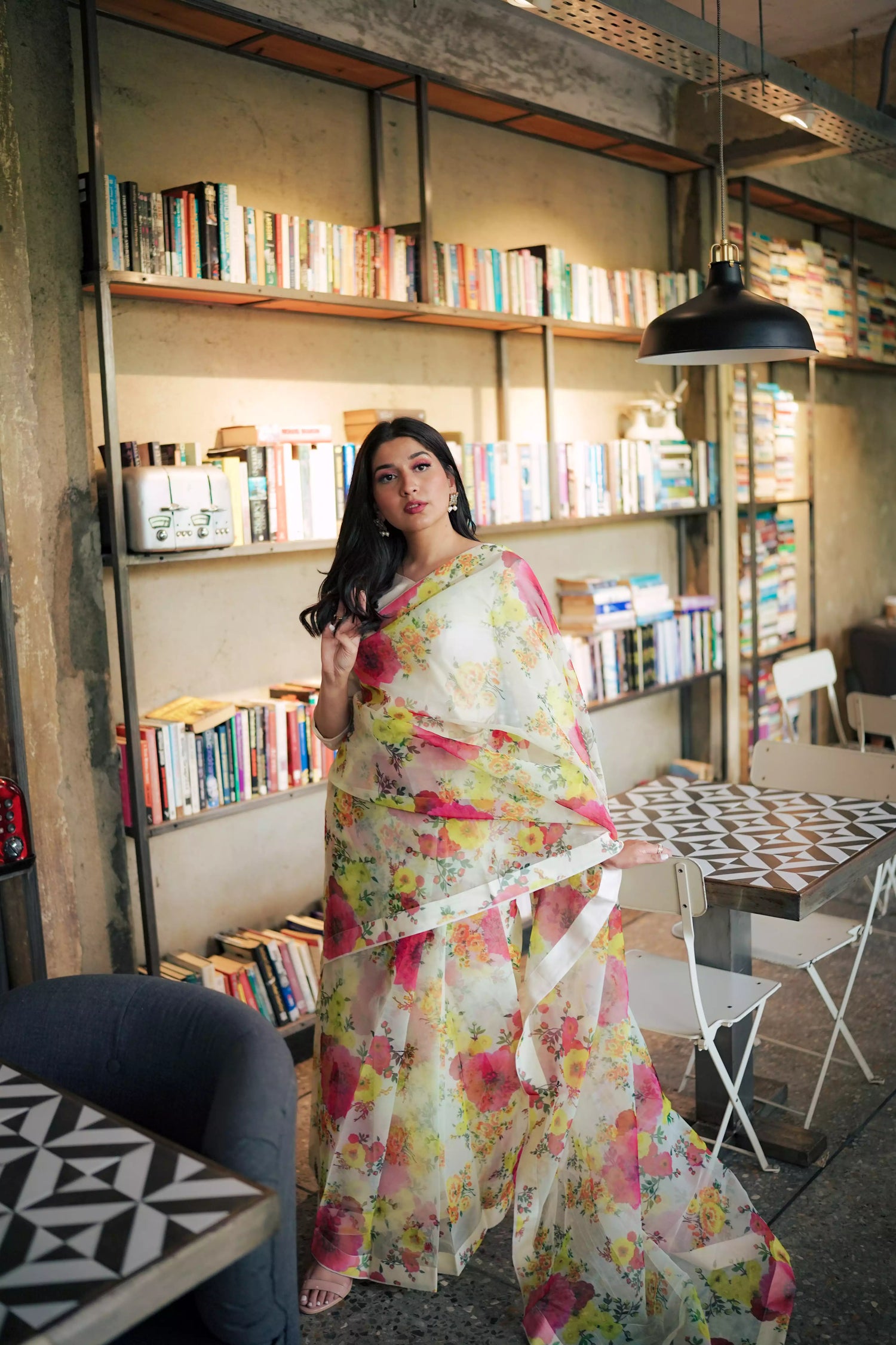 Cream floral printed organza saree with soft pastel patterns, paired with a matching Katan raw silk blouse and cotton petticoat; elegant drape ideal for festive and semi-formal occasions.