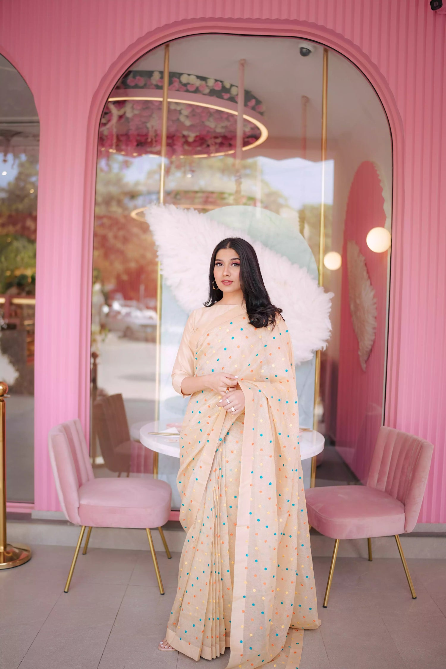 A saree adorned with multi-colored embroidered dots highlighting graceful attire.