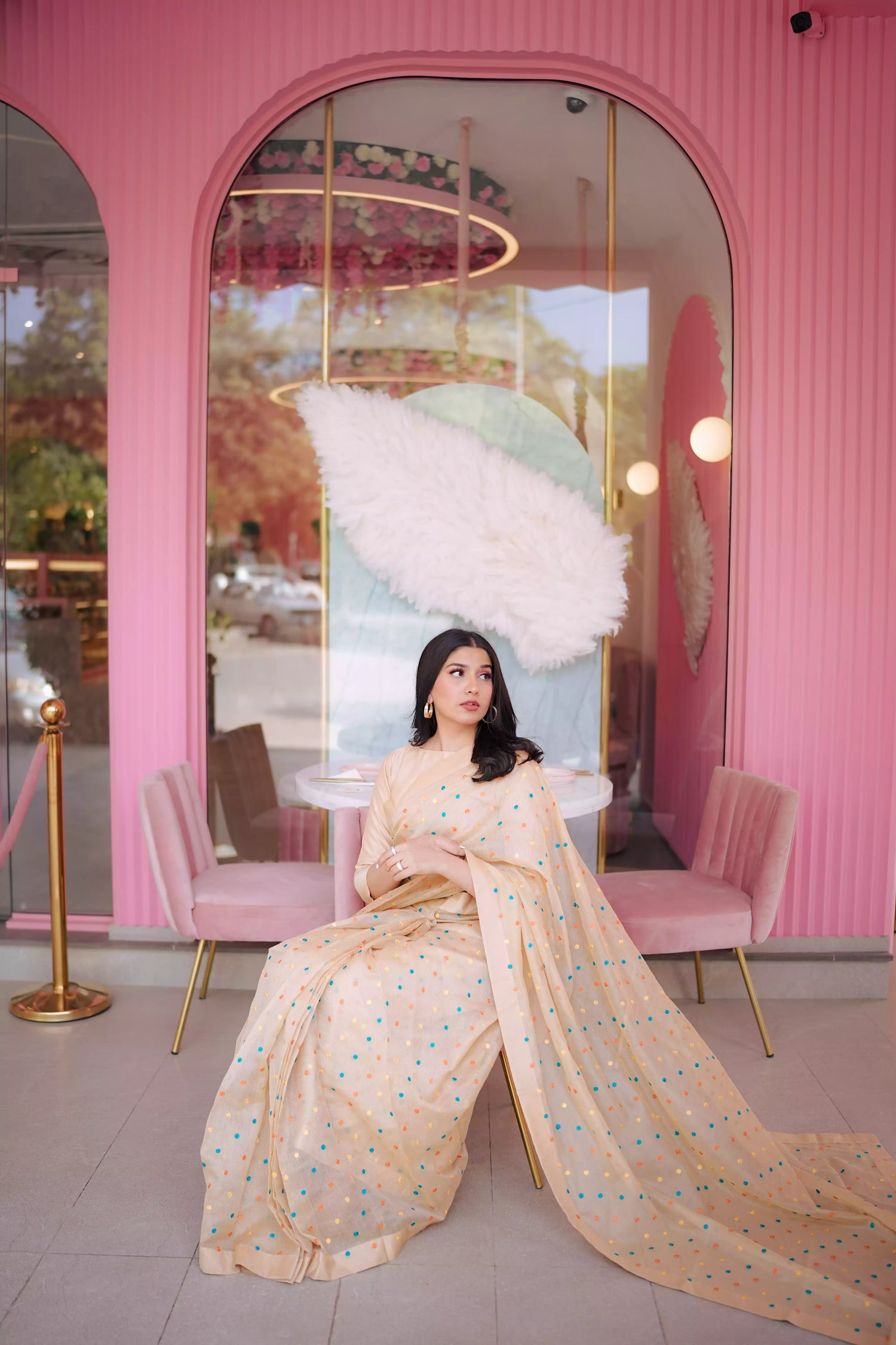 A saree adorned with multi-colored embroidered dots highlighting graceful attire.