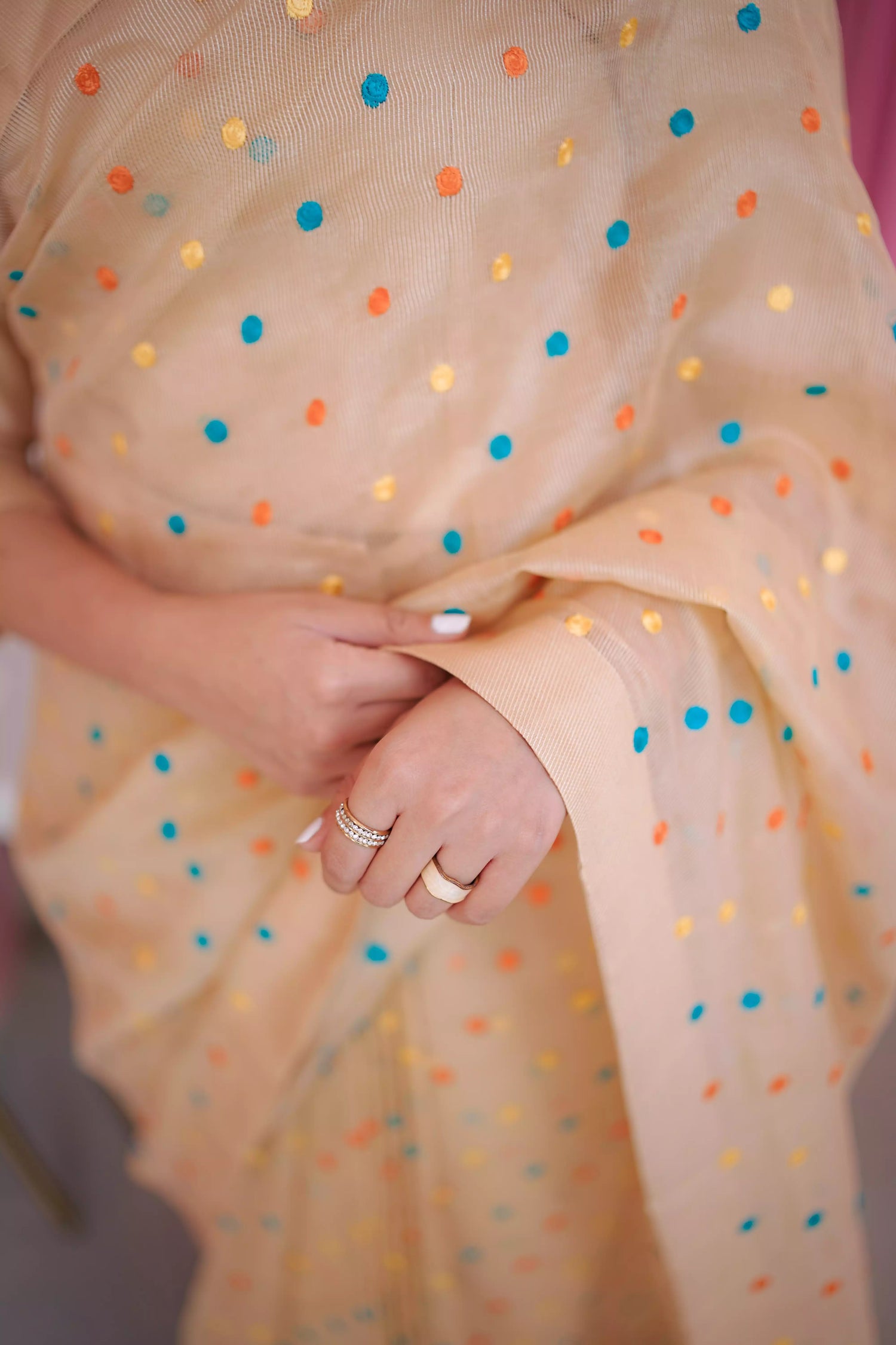 A saree adorned with multi-colored embroidered dots highlighting graceful attire.