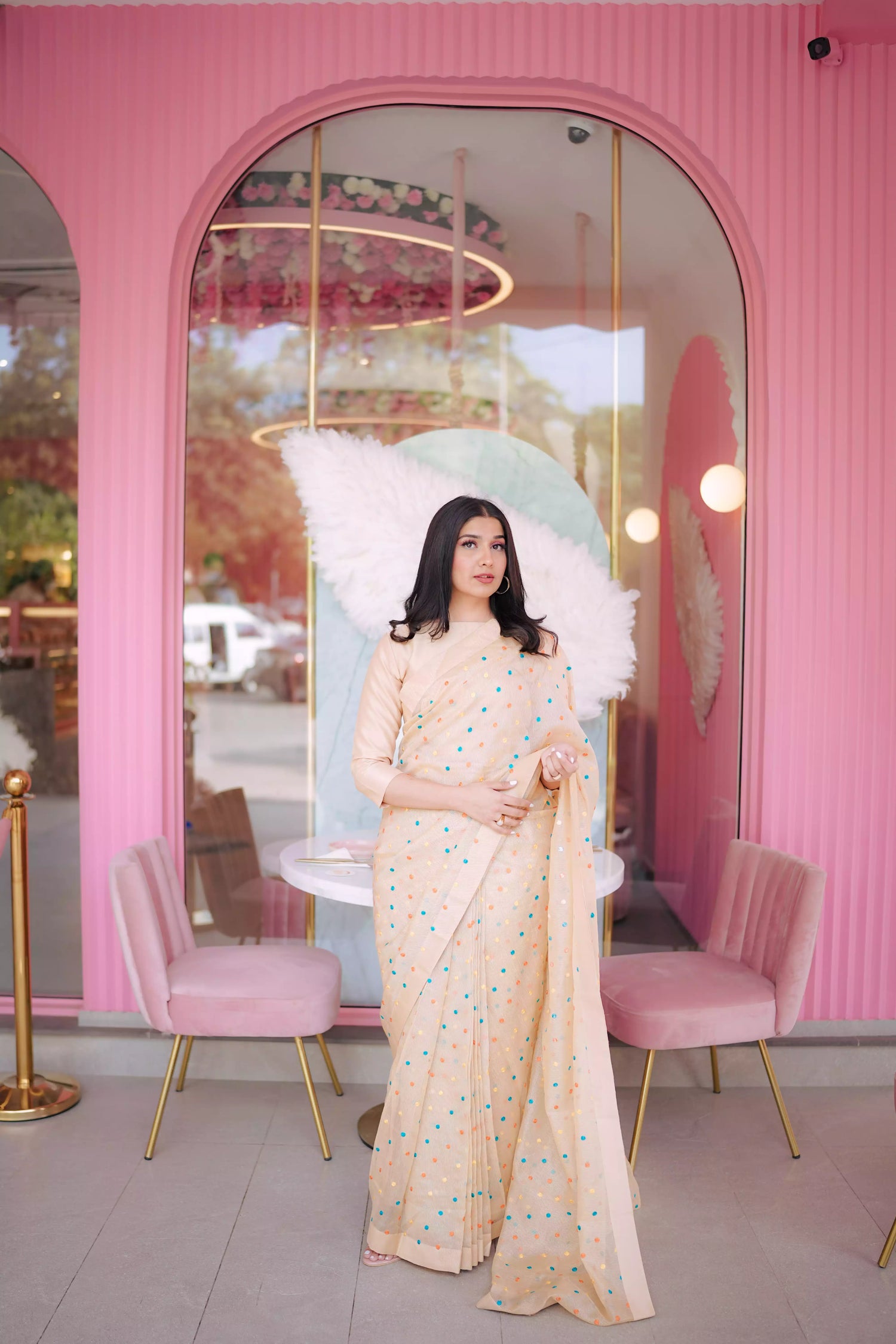 A saree adorned with multi-colored embroidered dots highlighting graceful attire.