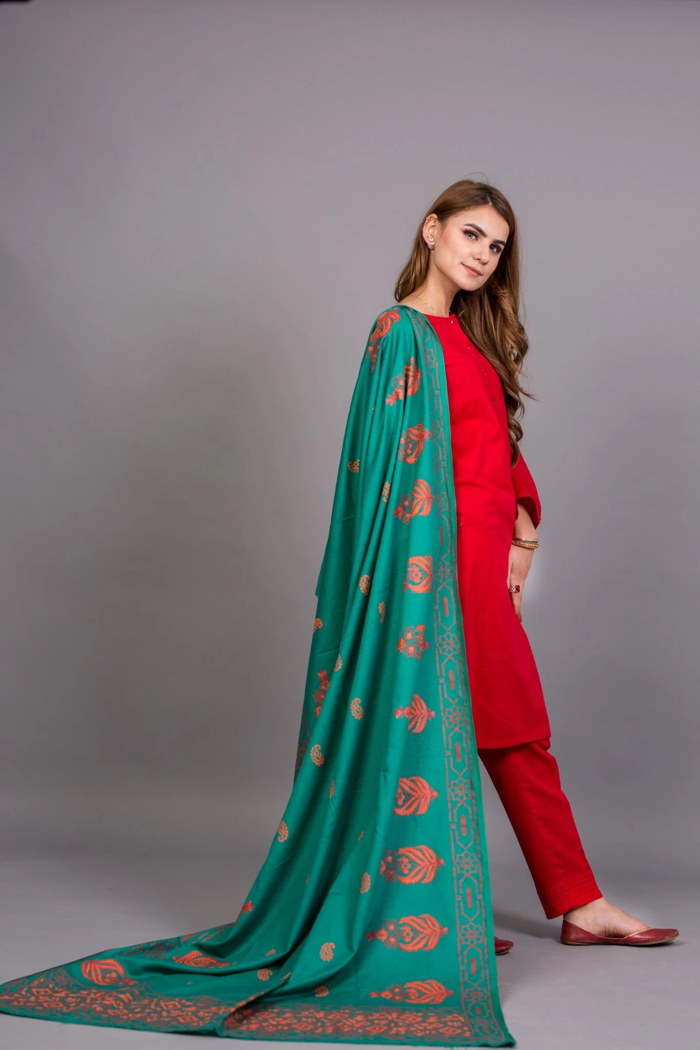 A stunning teal shawl featuring red and orange block printed motifs, crafted from soft and breathable Swiss Khadar fabric, perfect for semi-formal or formal events.