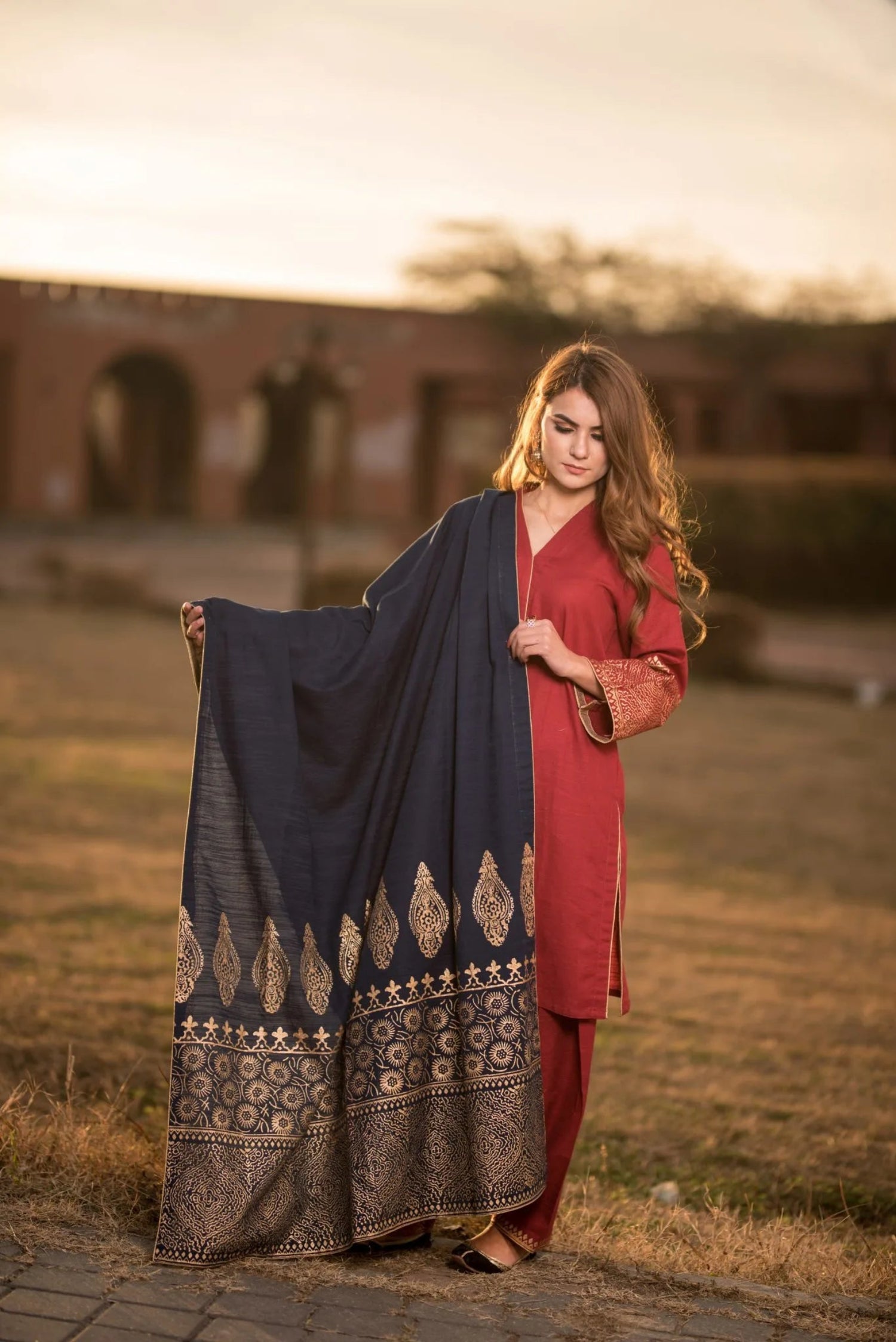 A navy blue shawl with golden block printed design adored with golden piko finishing exuding elegance and sophistication.
