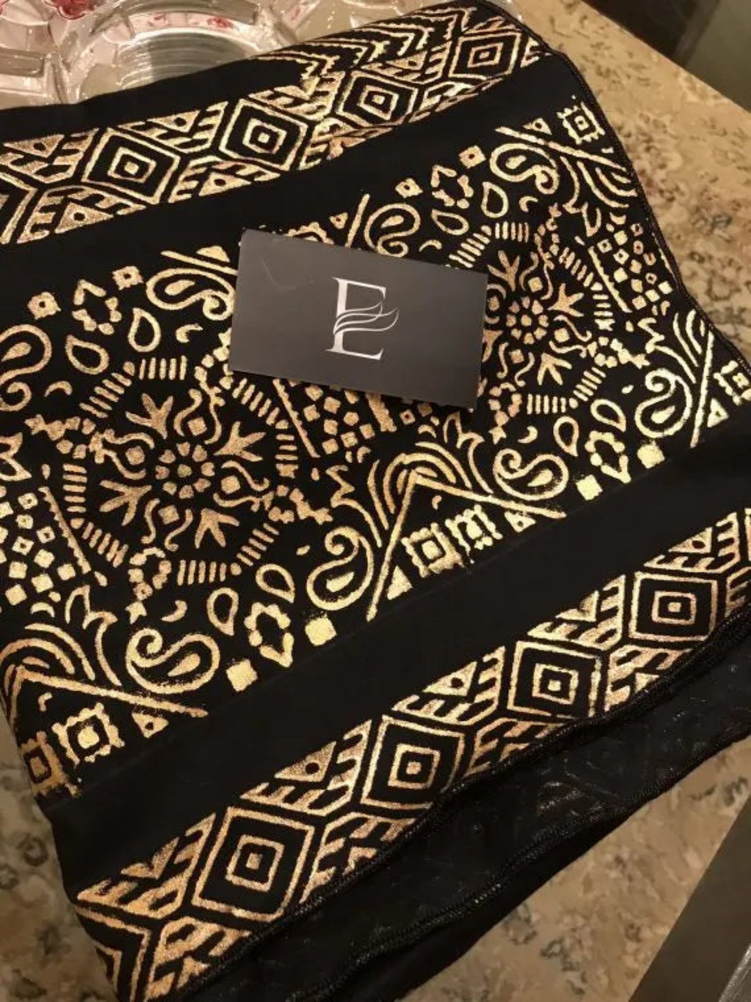 A luxurious shawl featuring geometric golden block printed design, adding a touch of regal charm and modern ensembles, ideal for every occasion.