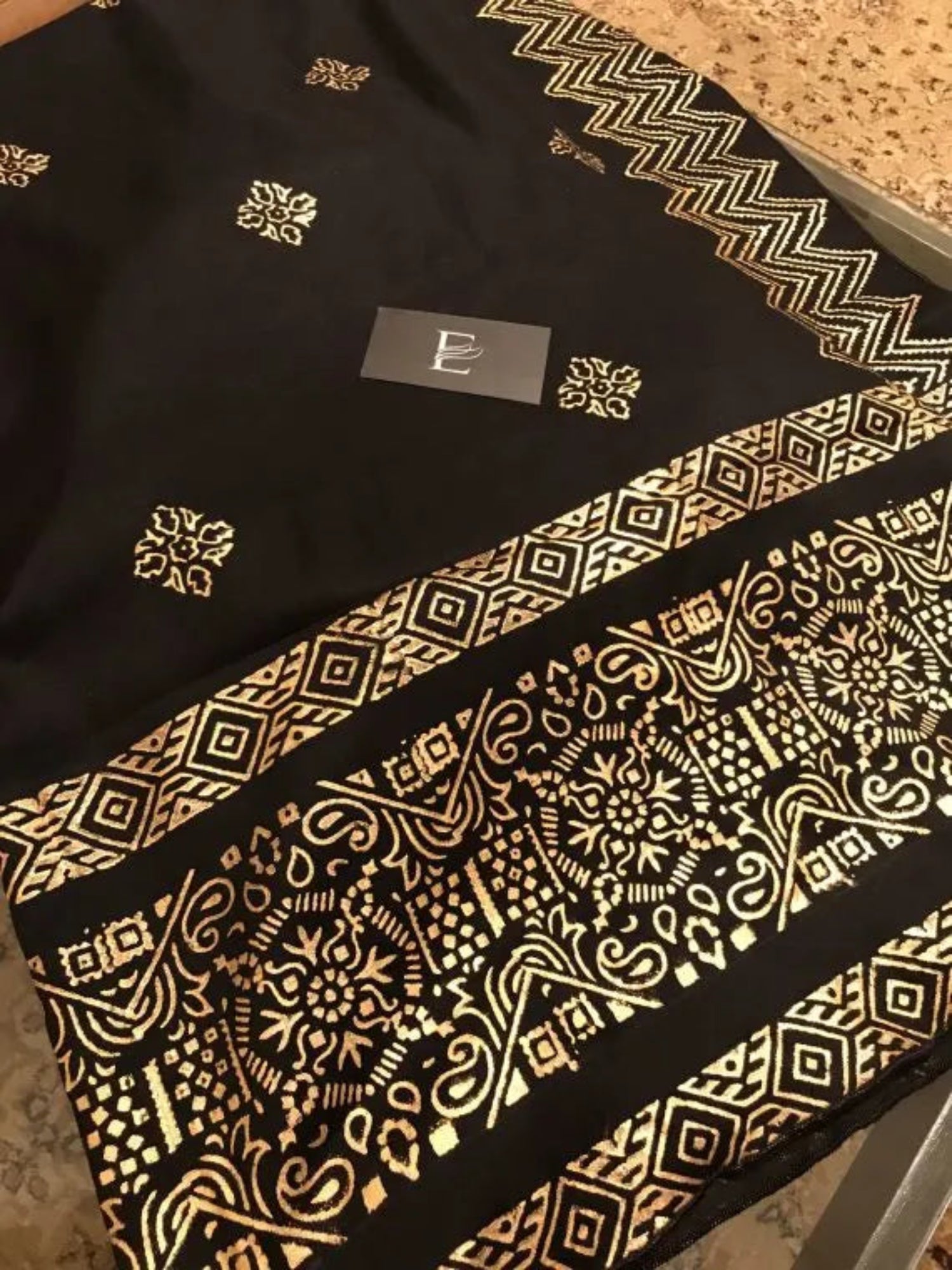 A luxurious shawl featuring geometric golden block printed design, adding a touch of regal charm and modern ensembles, ideal for every occasion.