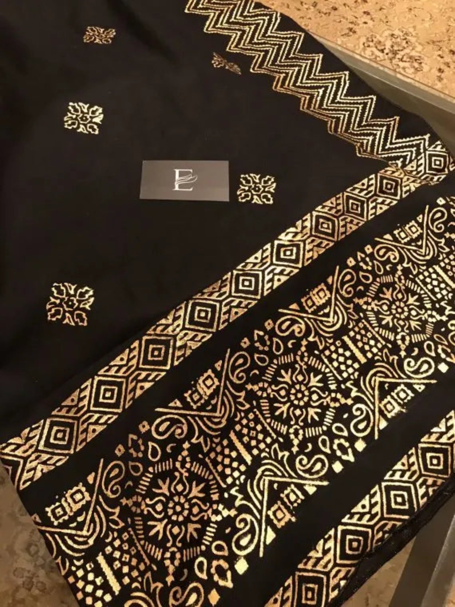A luxurious shawl featuring geometric golden block printed design, adding a touch of regal charm and modern ensembles, ideal for every occasion.