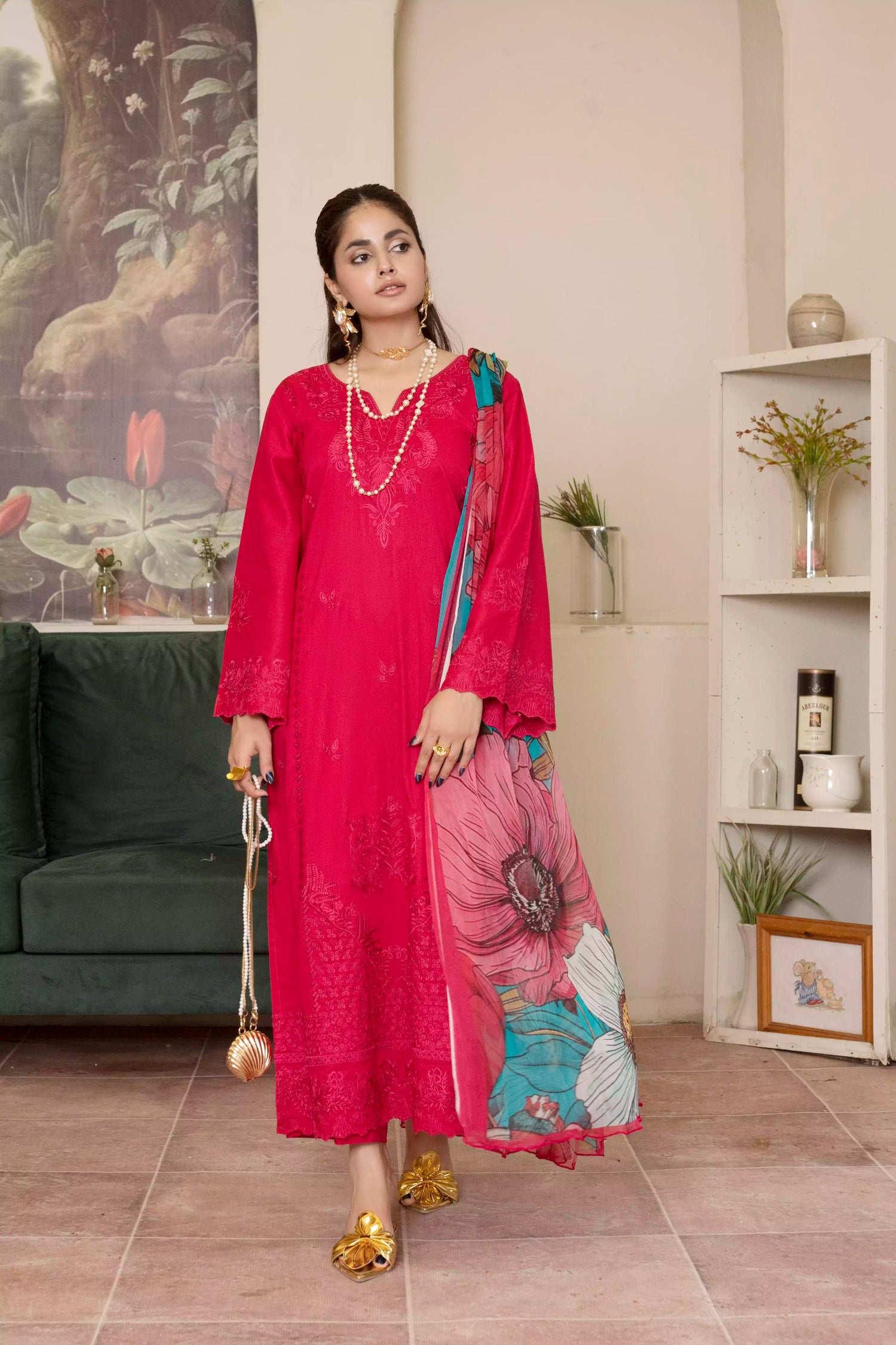 A deep red three piece suit complemented by a teal and pink floral dupatta, perfect for festive charm.