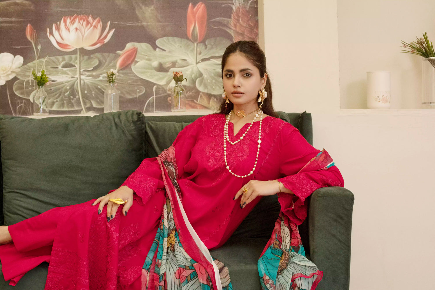 A deep red three piece suit complemented by a teal and pink floral dupatta, perfect for festive charm.