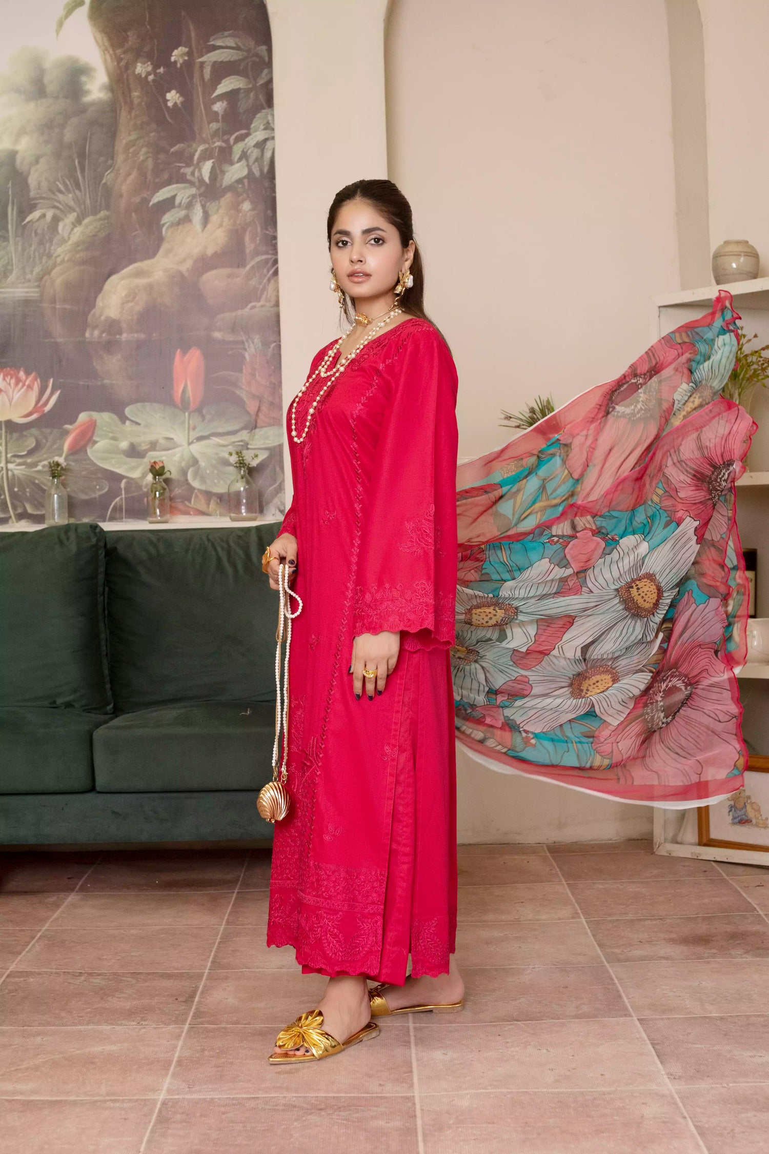A deep red three piece suit complemented by a teal and pink floral dupatta, perfect for festive charm.