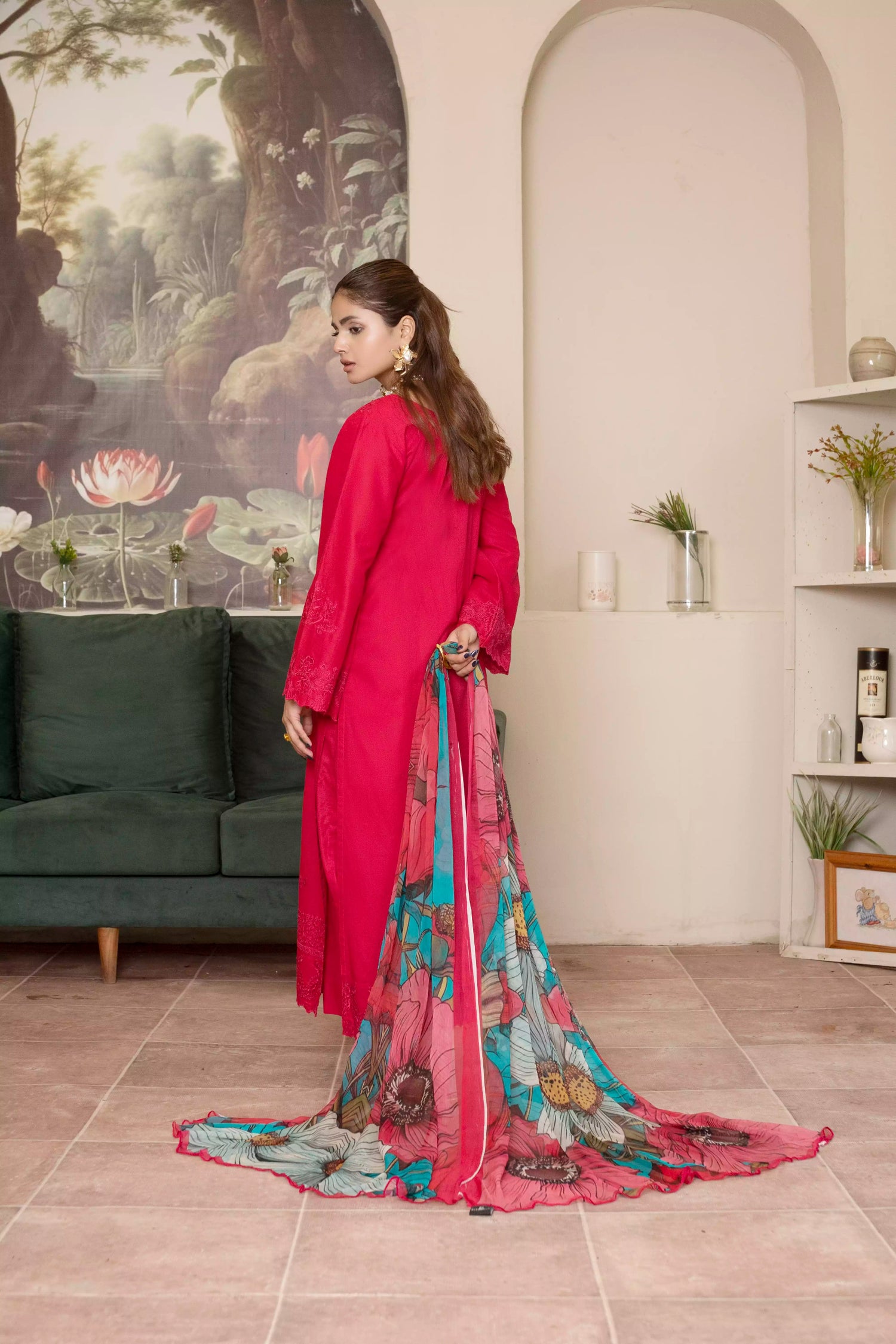 A deep red three piece suit complemented by a teal and pink floral dupatta, perfect for festive charm.