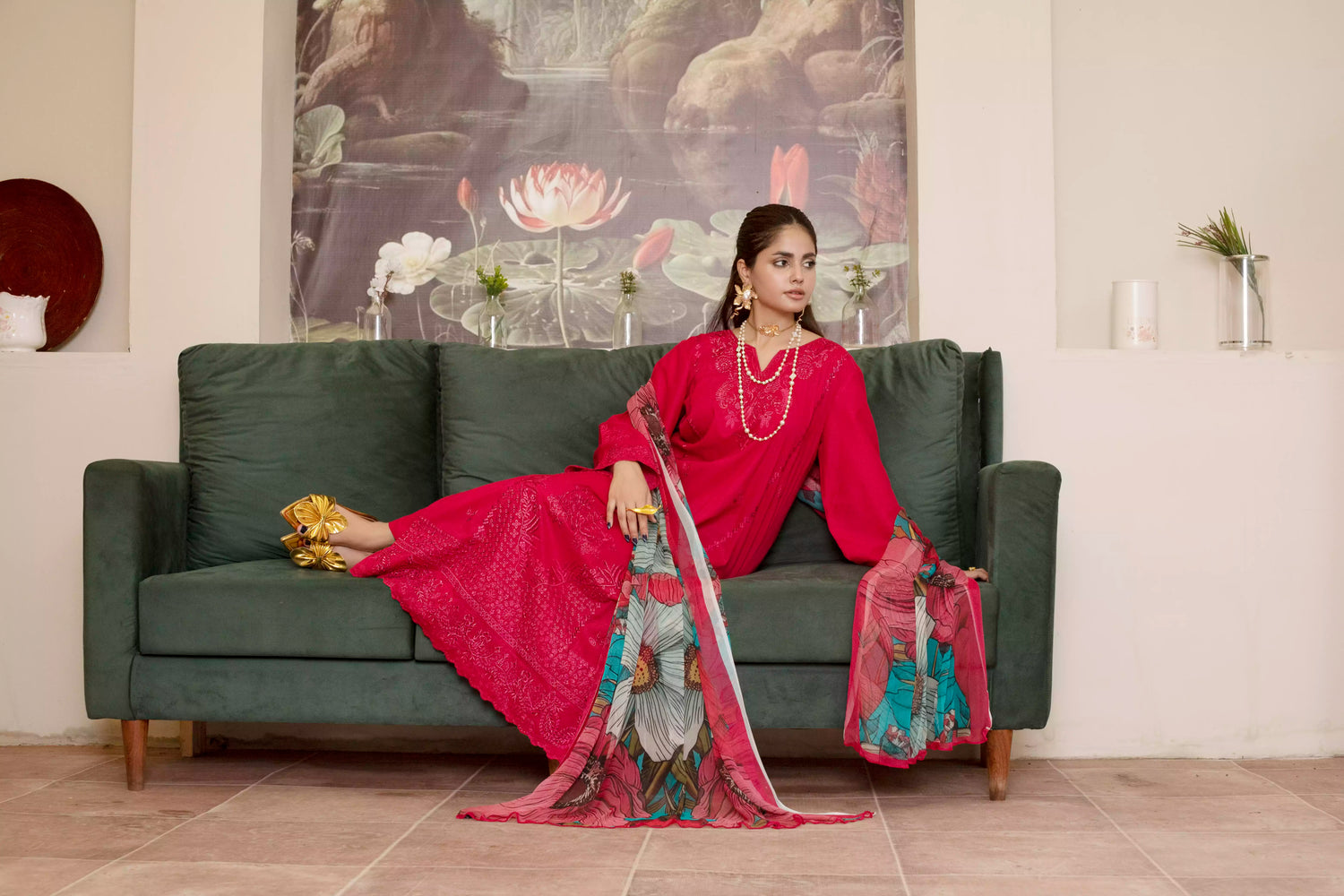 A deep red three piece suit complemented by a teal and pink floral dupatta, perfect for festive charm.