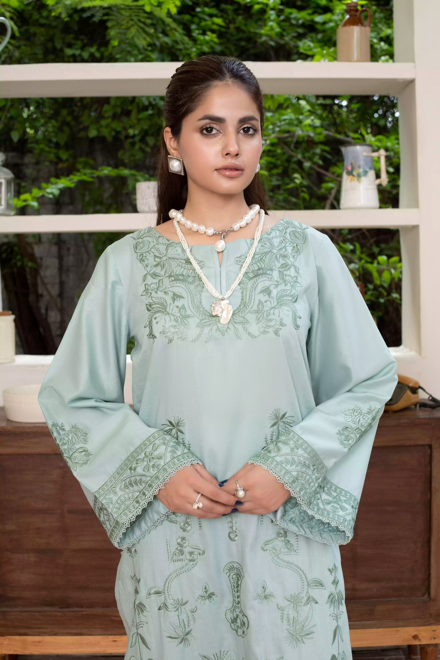 A pastel mint green design with embroidery on sleeves and intricate floral patterns, paired with a vibrant, tropical-themed printed dupatta.