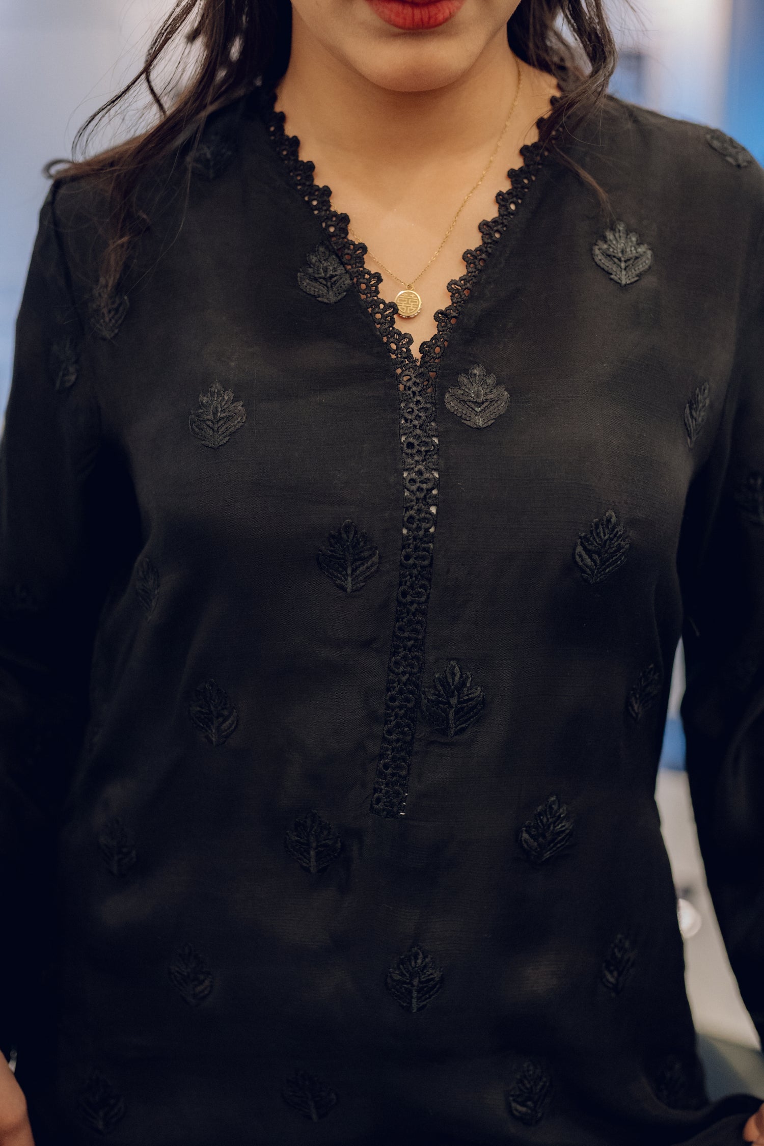 A black embroidered dress featuring celestial-inspired motifs and intricate lace detailing on the sleeves and pants, paired with a white organza dupatta adorned with coordinated embroidery for a refined, elegant contrast.
