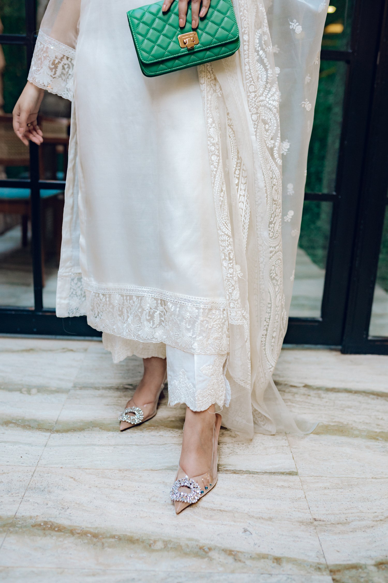 A white dress featuring intricate lace and embroidered organza, exuding elegance and sophistication.