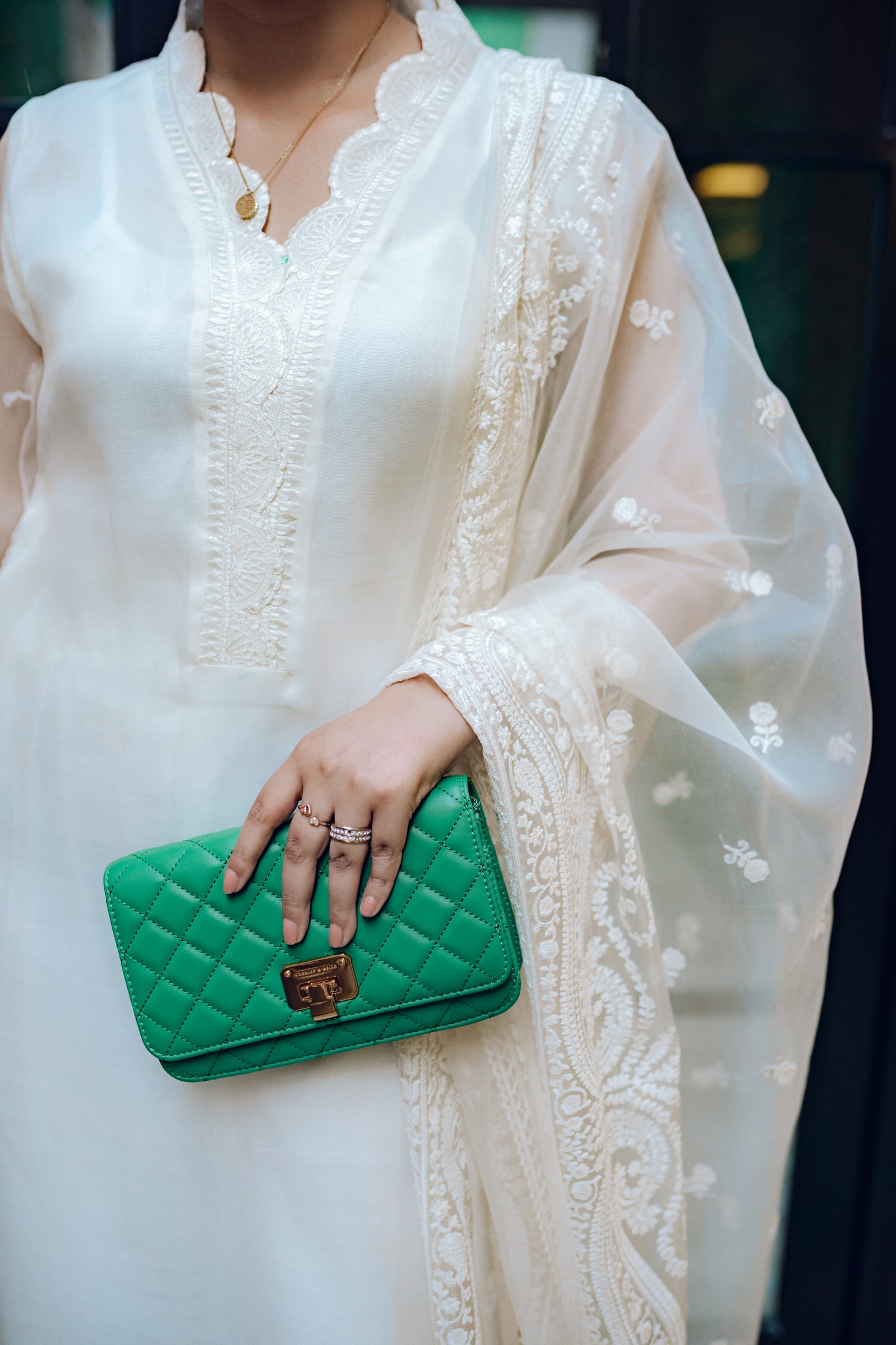 A white dress featuring intricate lace and embroidered organza, exuding elegance and sophistication.