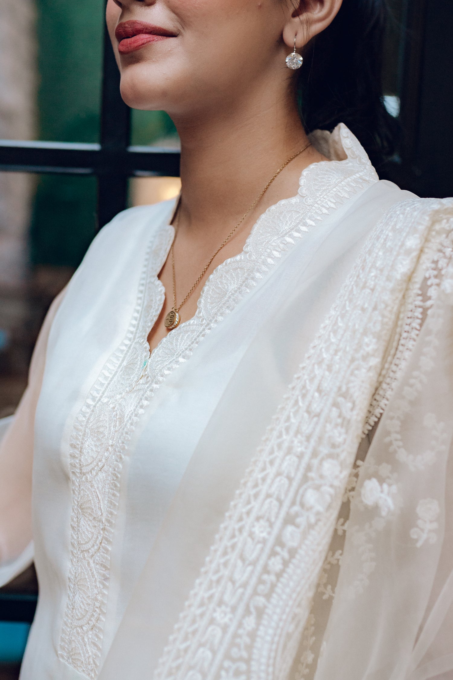 A white dress featuring intricate lace and embroidered organza, exuding elegance and sophistication.