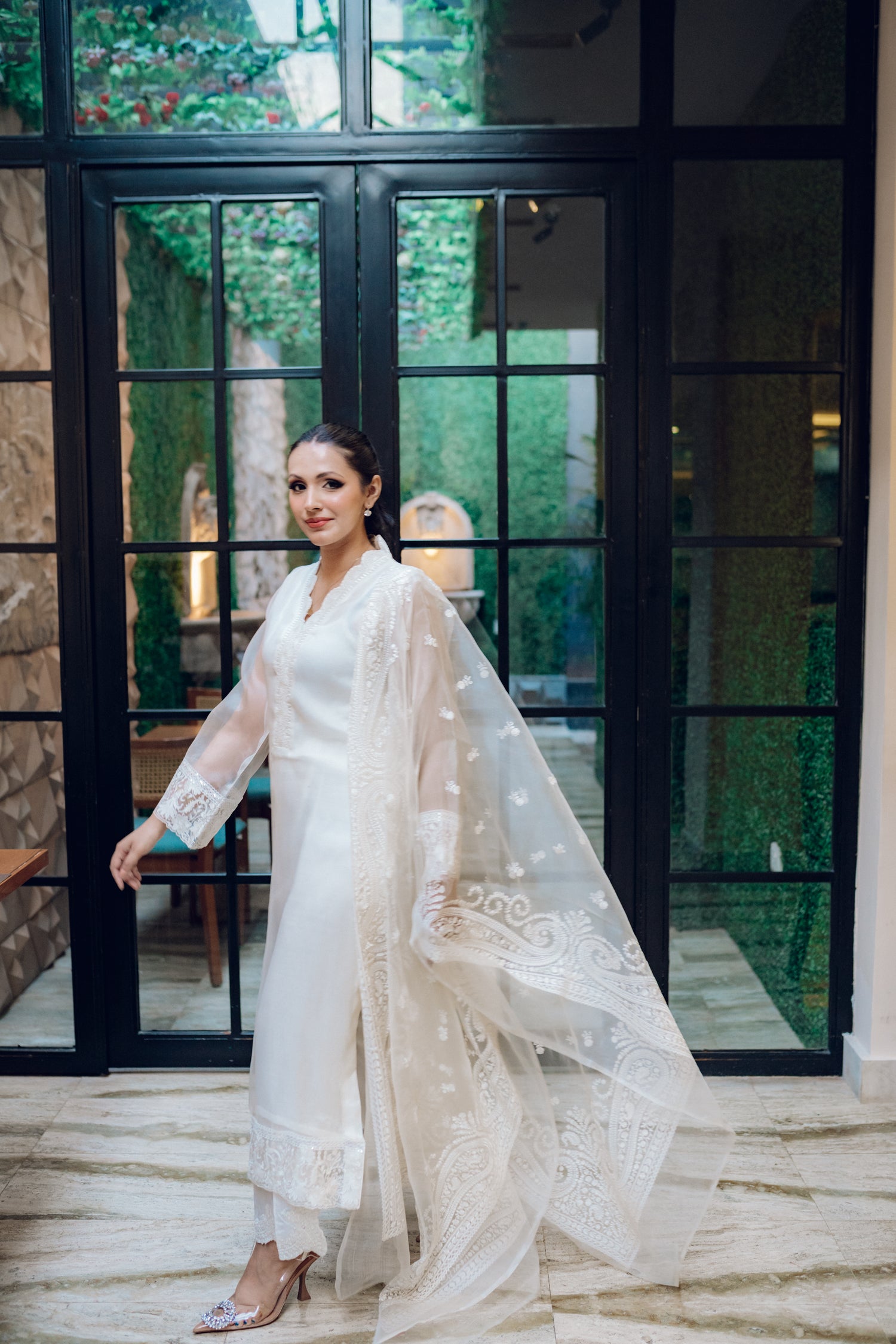 A white dress featuring intricate lace and embroidered organza, exuding elegance and sophistication.