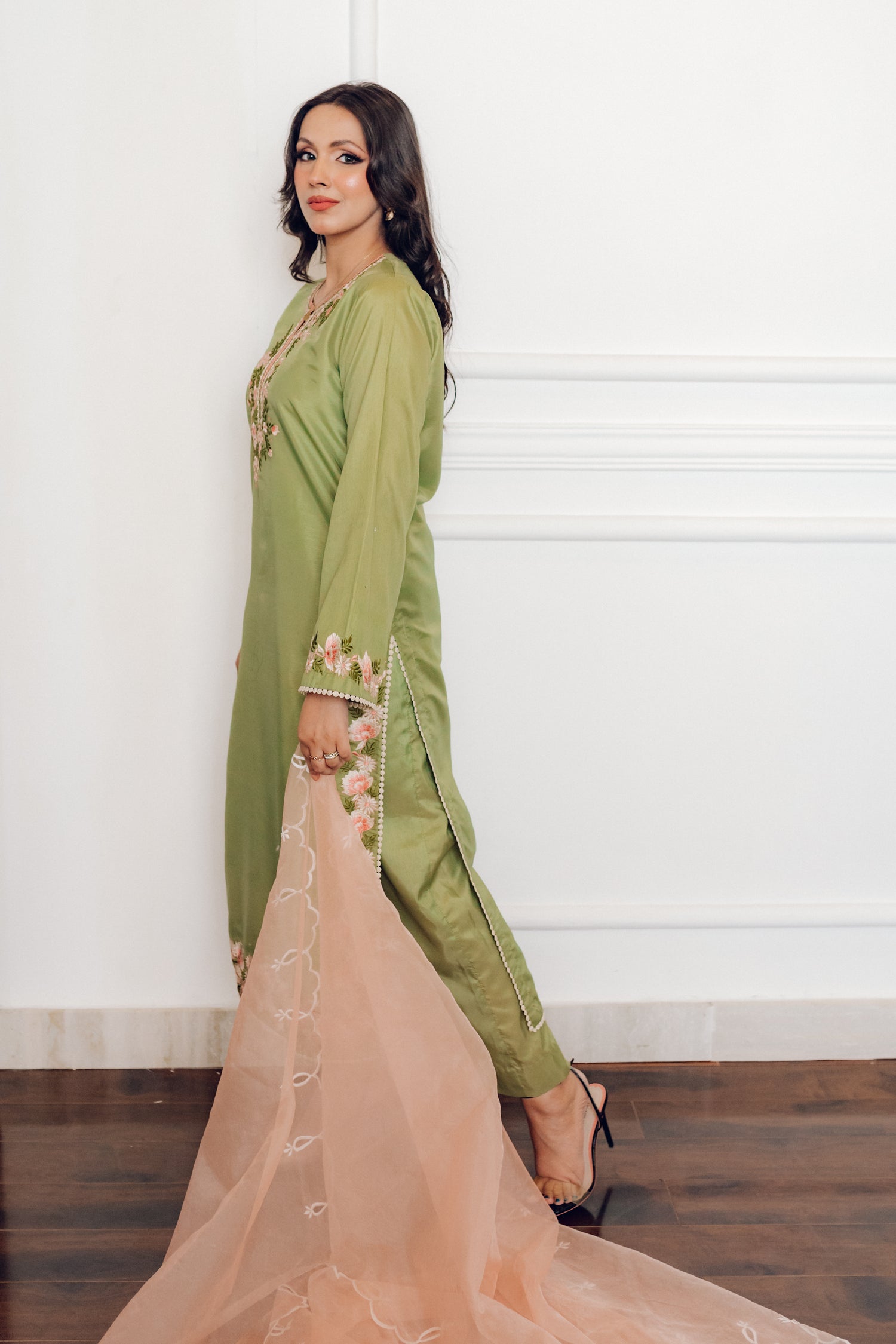 Vibrant leaf green colored dress with floral embroidery, paired with a peach pink cutwork dupatta, capturing the essence of spring with nature-inspired elegance and graceful charm.