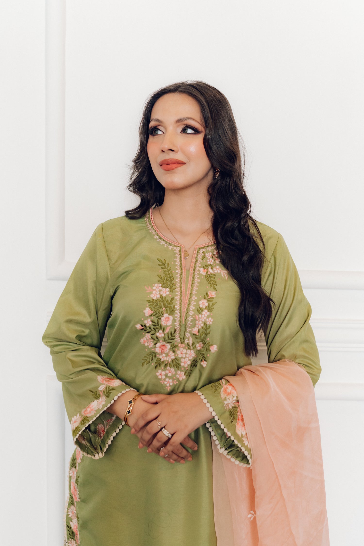 Vibrant leaf green colored dress with floral embroidery, paired with a peach pink cutwork dupatta, capturing the essence of spring with nature-inspired elegance and graceful charm.