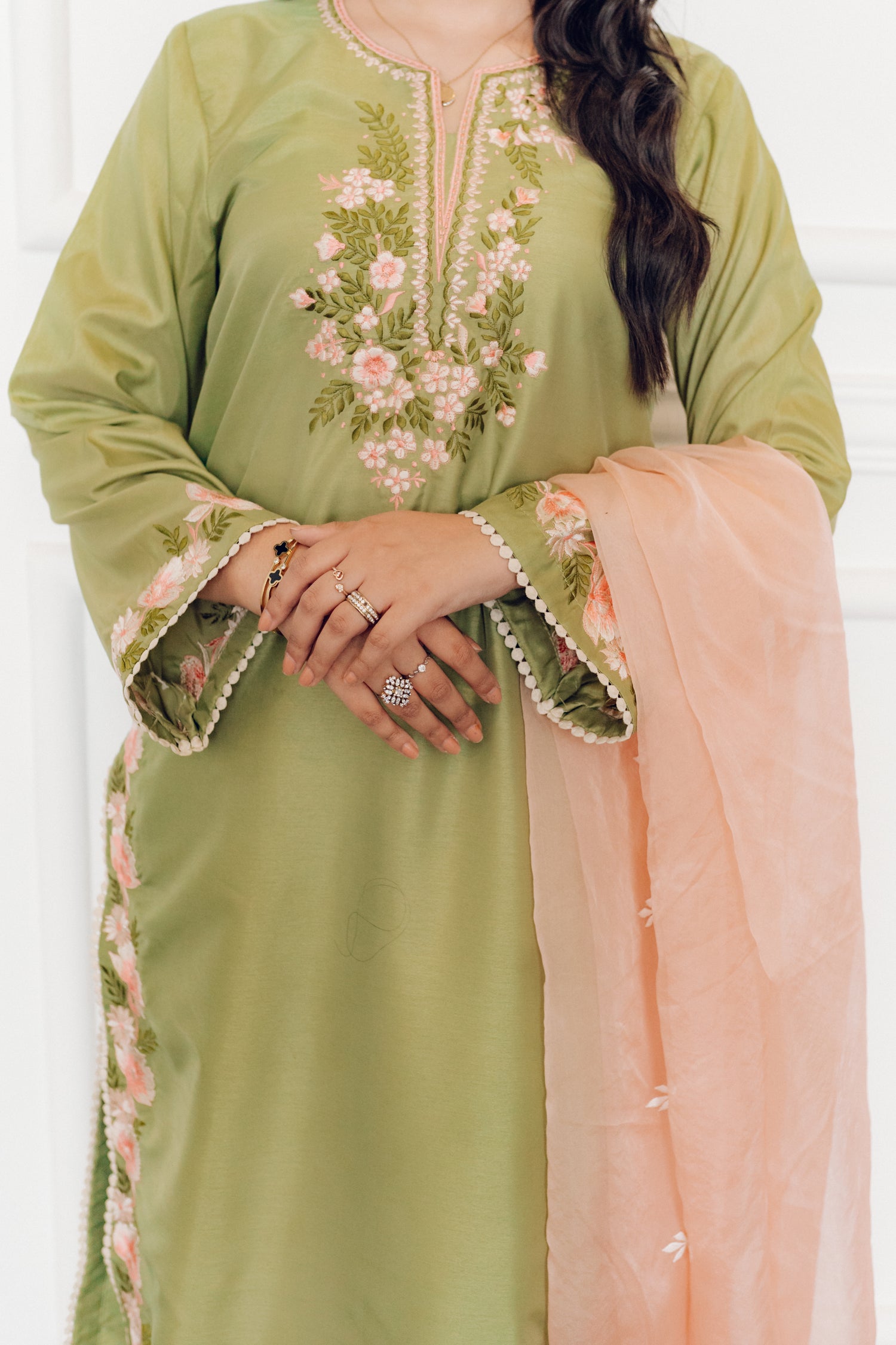 Vibrant leaf green colored dress with floral embroidery, paired with a peach pink cutwork dupatta, capturing the essence of spring with nature-inspired elegance and graceful charm.