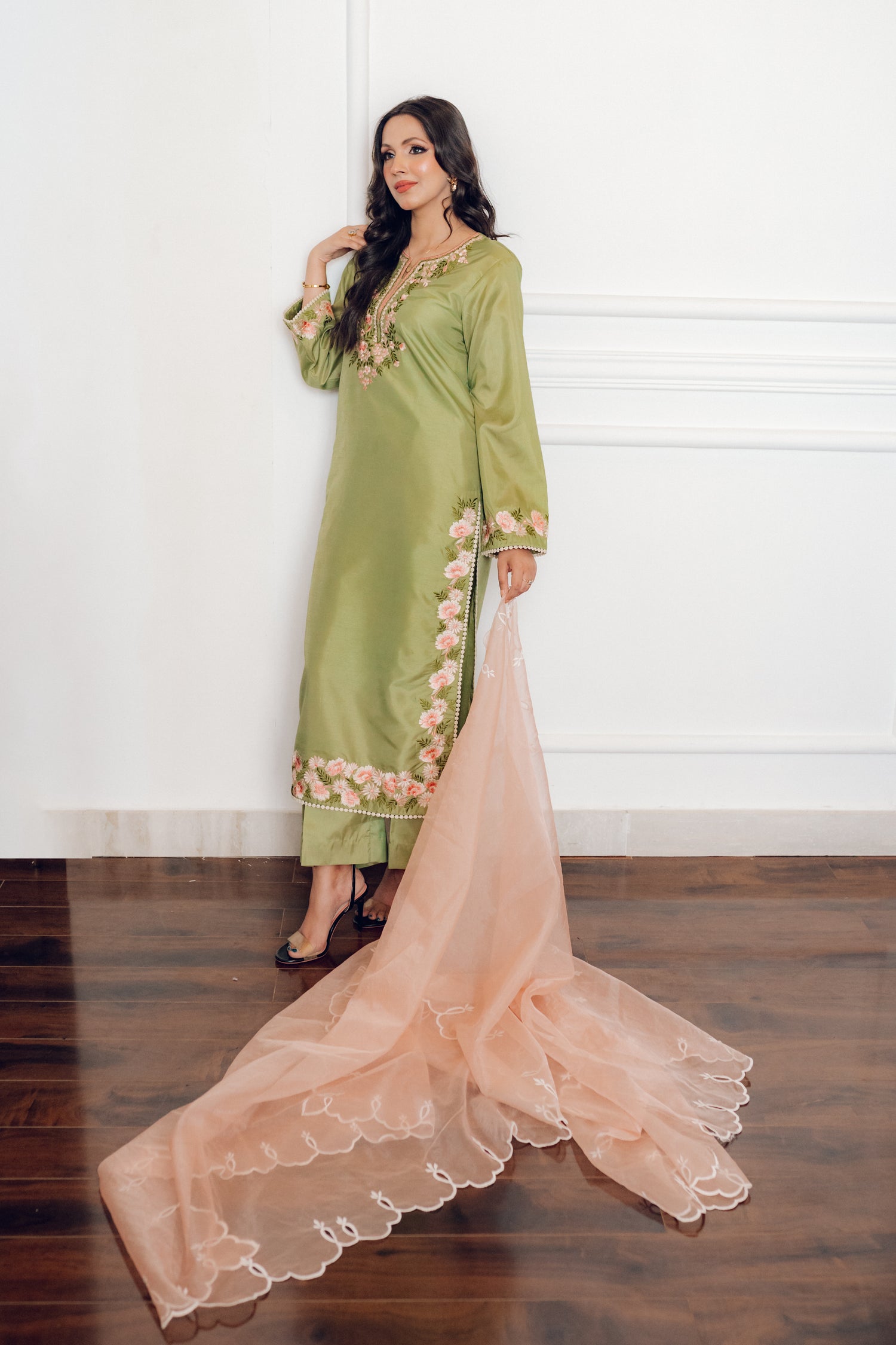 Vibrant leaf green colored dress with floral embroidery, paired with a peach pink cutwork dupatta, capturing the essence of spring with nature-inspired elegance and graceful charm.
