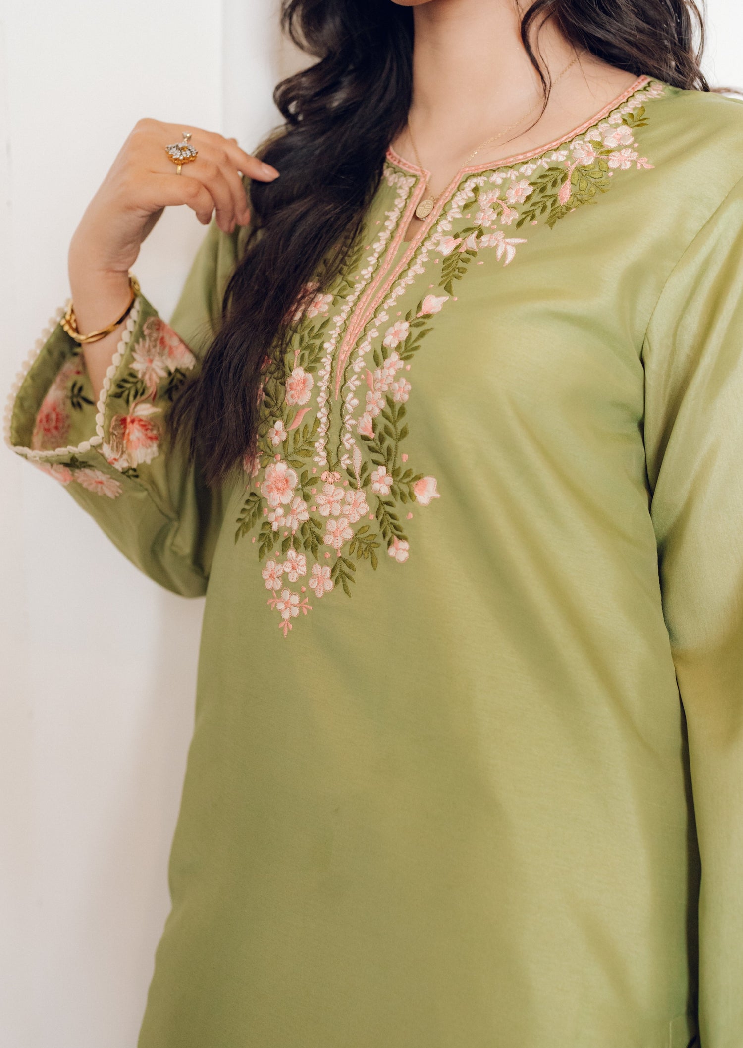 Vibrant leaf green colored dress with floral embroidery, paired with a peach pink cutwork dupatta, capturing the essence of spring with nature-inspired elegance and graceful charm.