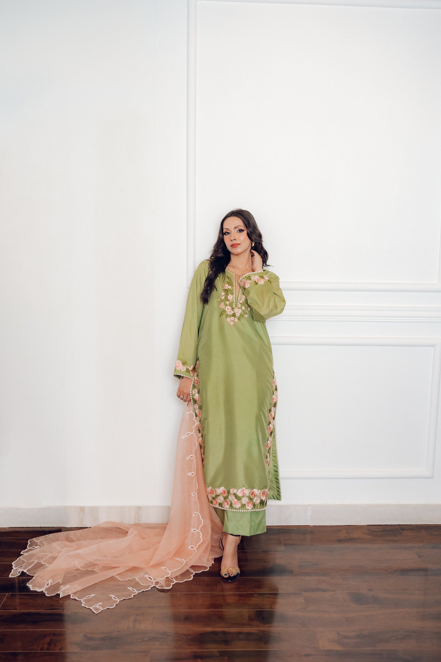 Vibrant leaf green colored dress with floral embroidery, paired with a peach pink cutwork dupatta, capturing the essence of spring with nature-inspired elegance and graceful charm.