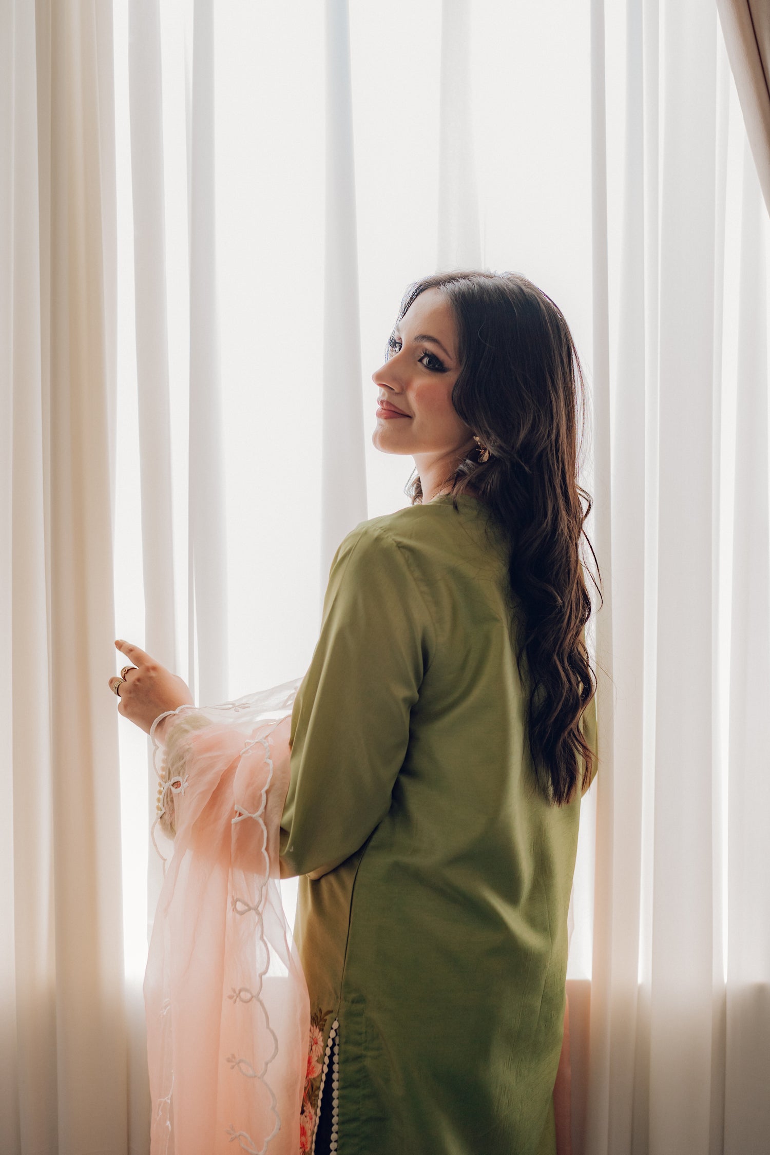 Vibrant leaf green colored dress with floral embroidery, paired with a peach pink cutwork dupatta, capturing the essence of spring with nature-inspired elegance and graceful charm.