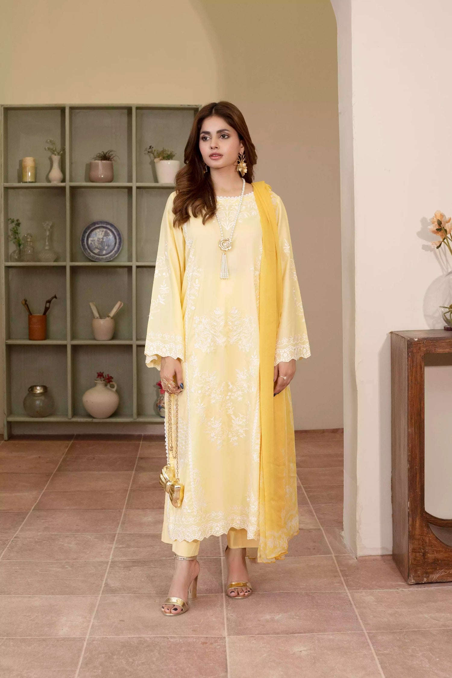 Stunning yellow embroidered suit, featuring intricate white embroidery, paired with matching plain pants and chiffon dupatta.