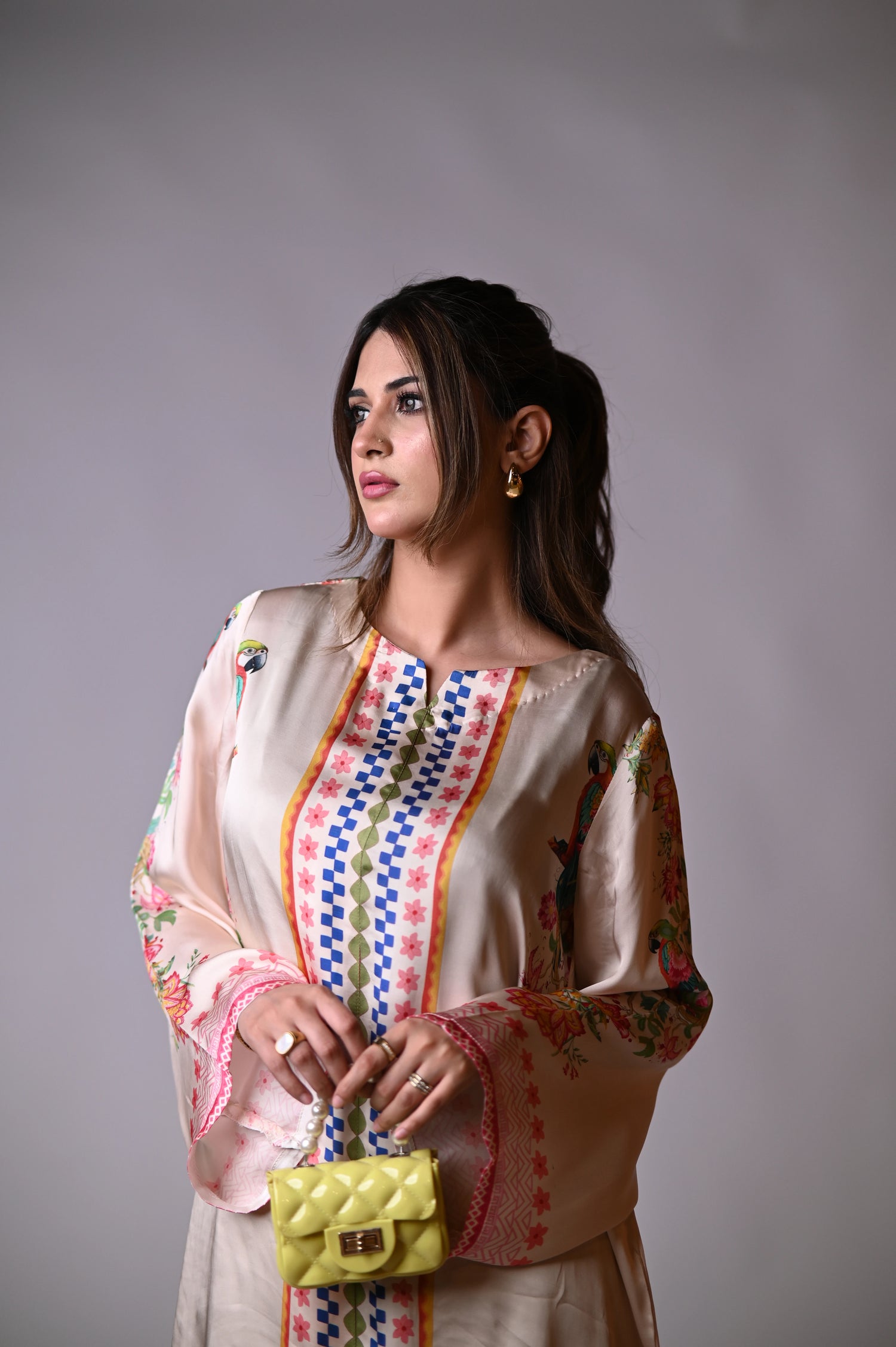 A printed silk cord set in beige featuring vibrant floral and parrot motifs, crafted from luxurious silk for a soft, elegant drape.
