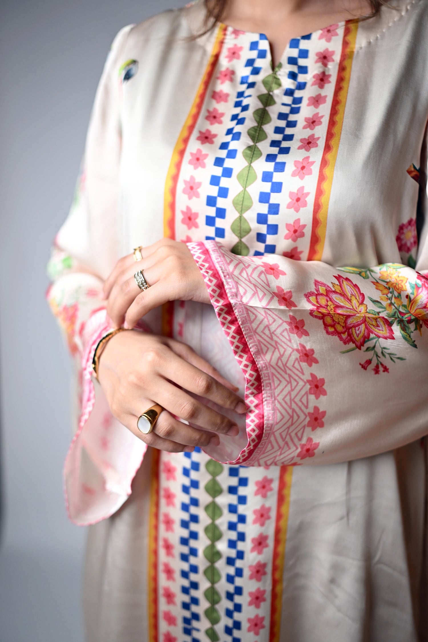 A printed silk cord set in beige featuring vibrant floral and parrot motifs, crafted from luxurious silk for a soft, elegant drape.