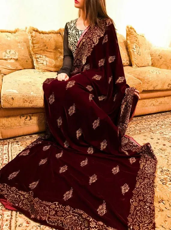 Maroon velvet shawl with an embroidered gold block printed border, featuring screen printed floral motifs showcasing traditional craftsmanship.