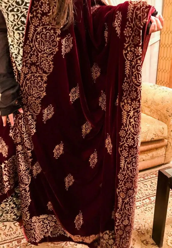 Maroon velvet shawl with an embroidered gold block printed border, featuring screen printed floral motifs showcasing traditional craftsmanship.