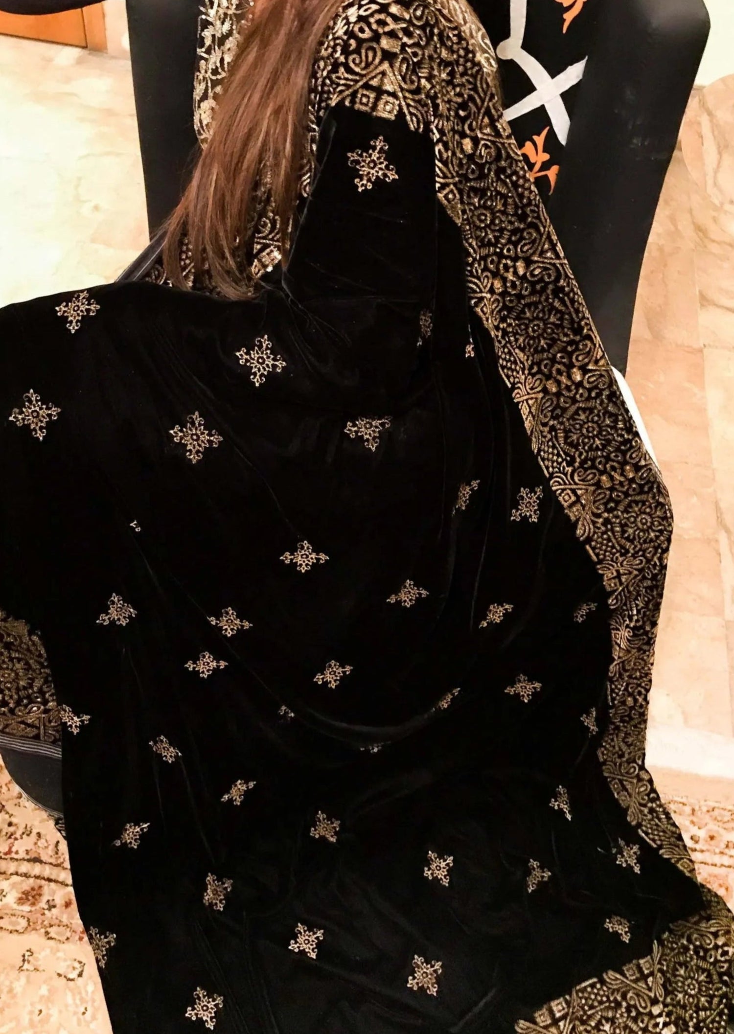 A Geometric Velvet Shawl showcasing intricate block printed motifs complimented with shimmering golden tila embroidery for stylish, glamourous look.